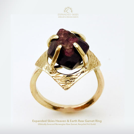 The Expanded Skies Heaven and Earth Raw Garnet Ring has a beautiful raw Norwegian garnet set in 9ct gold. The garnet is set in a distinctive completely handcrafted engraved claw setting. This is a unique piece, one-of-a-kind. Handcrafted on the edge of Dartmoor and made from high quality recycled gold, Hallmarked by the London Assay Office.