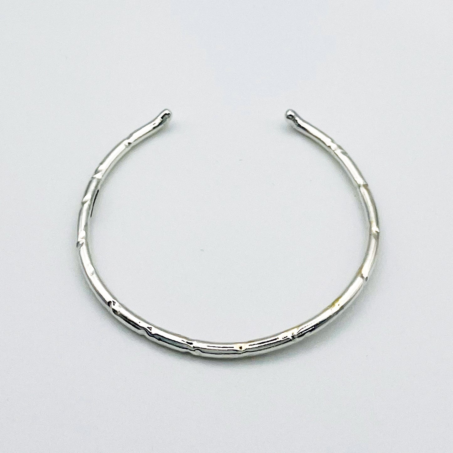 Expanded Skies Dartmoor Torc Bangle combines the classic shape with the textures and hand engraving that evokes the granite landscape.
The bangle is totally handcrafted on the edge of Dartmoor in the Expanded Skies signature hand-drawn aesthetic. Made from high quality recycled sterling silver. For men and women, simple, beautiful.