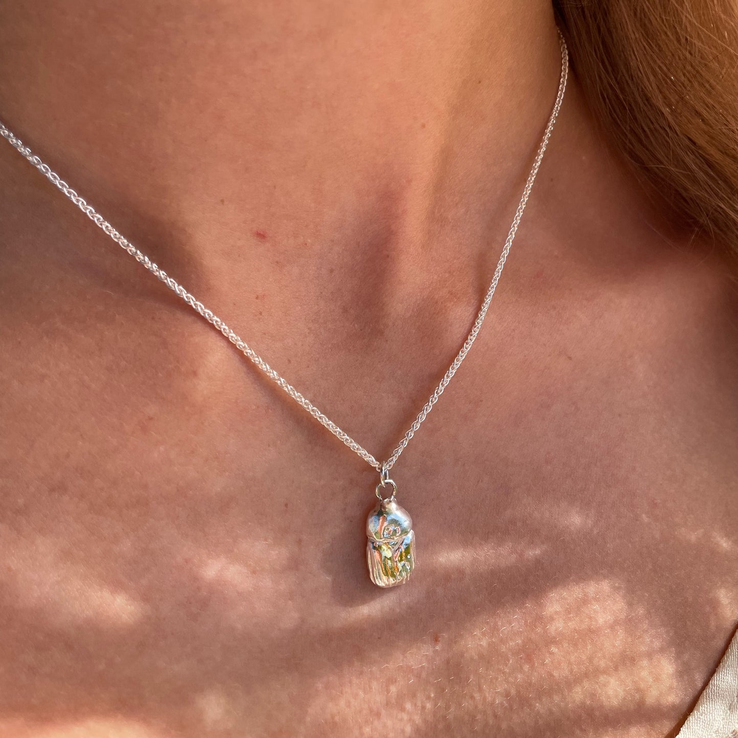 The Expanded Skies Dartmoor Scarab Pendant Necklace is inspired by the Dumbledore or Dor beetle, recycled fine silver with 24ct gold accents, worn on Dartmoor.