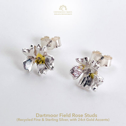 The Expanded Skies Dartmoor Field Rose Studs captures the joyous simple beauty of the field rose, Rosa arvensis, that is seen weaving brightly through the Dartmoor hedgerows and woodland.
Handcrafted in recycled fine silver with recycled 24ct gold accents and recycled sterling silver ear pins and scrolls.