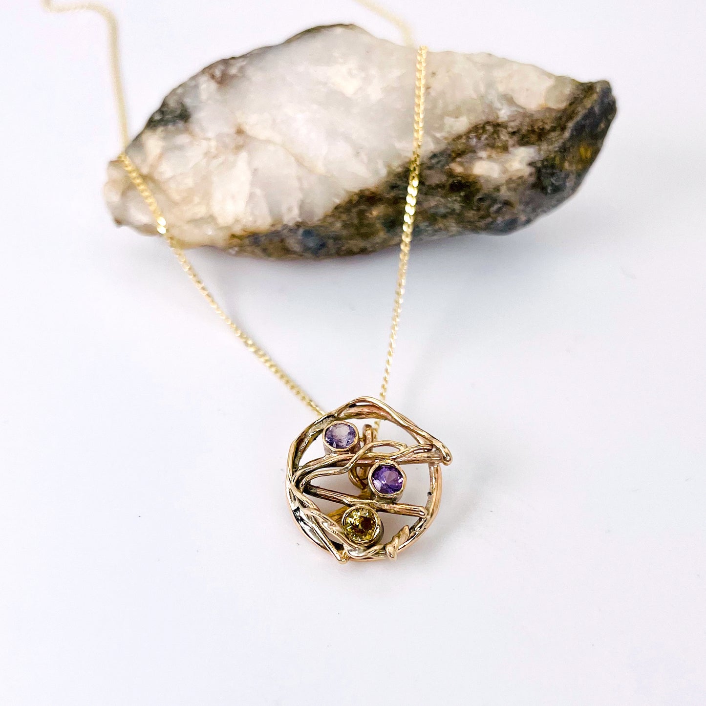 The Expanded Skies Haytor Heather and Gorse Amethyst and Sapphire Pendant evokes the beautiful yellows of the gorse and purples of the heather with an ethically sourced yellow sapphire and two amethysts held in twisting branches of 9ct yellow gold. The pendant comes with a 9ct gold chain, a choice of lengths are available.