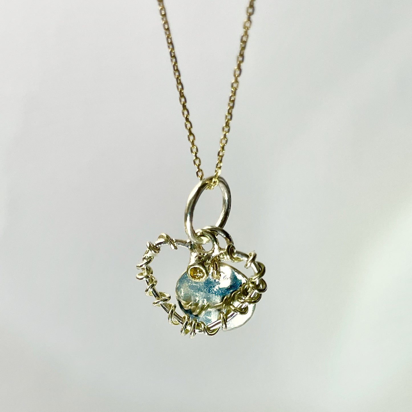 Expanded Skies Sapphire Yellow Heart Pendant has a beautiful ethically sourced Sri Lankan yellow faceted sapphire set in 9ct gold on a silver heart wound with 9ct gold accompanied by a small silver disk. Totally handcrafted on the edge of Dartmoor and made from high quality recycled sterling silver and recycled gold. Understated and beautiful, it can be worn every day or for special occasions.