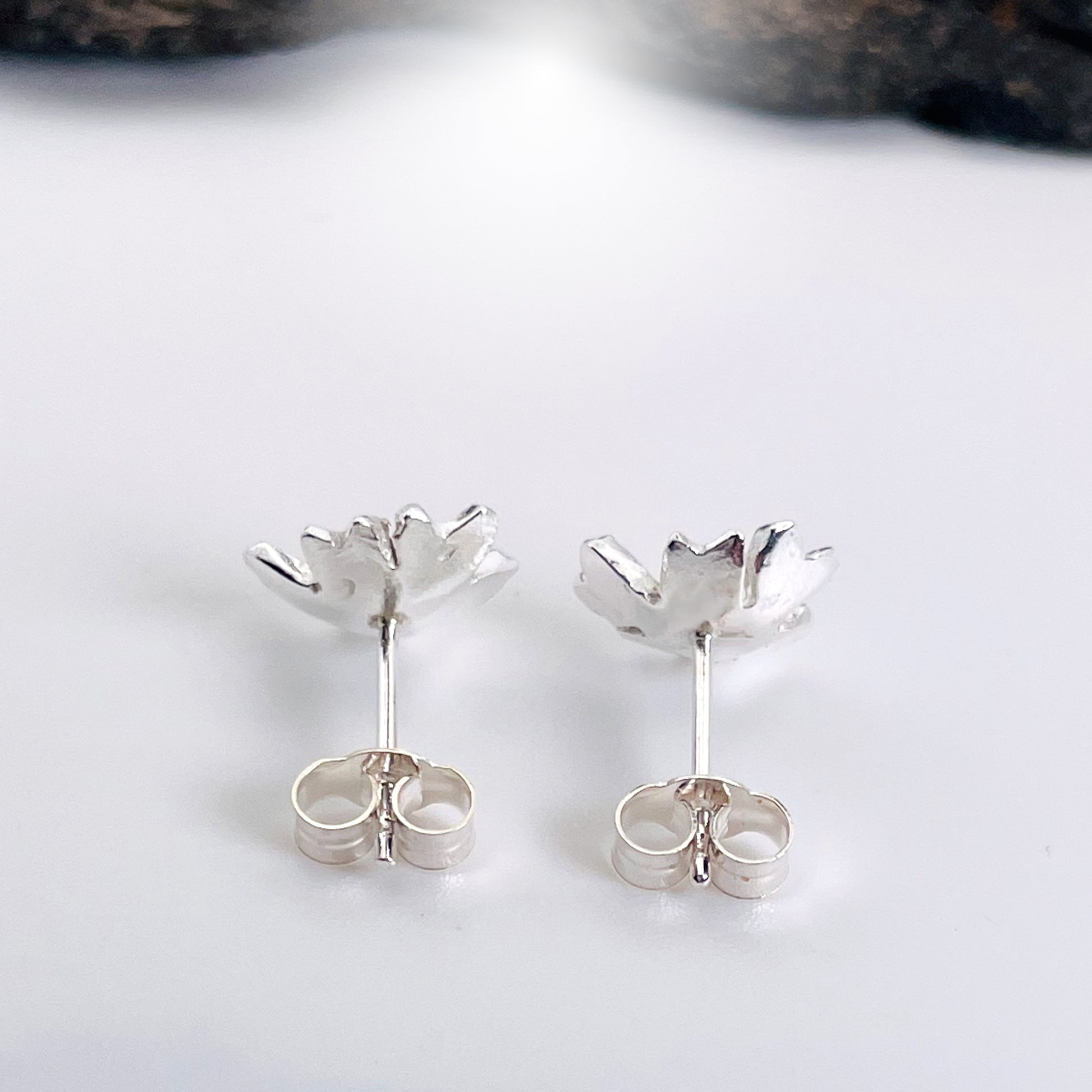 The Expanded Skies Dartmoor Field Rose Studs captures the joyous simple beauty of the field rose, Rosa arvensis, that is seen weaving brightly through the Dartmoor hedgerows and woodland.
Handcrafted in recycled fine silver with recycled 24ct gold accents and recycled sterling silver ear pins and scrolls.