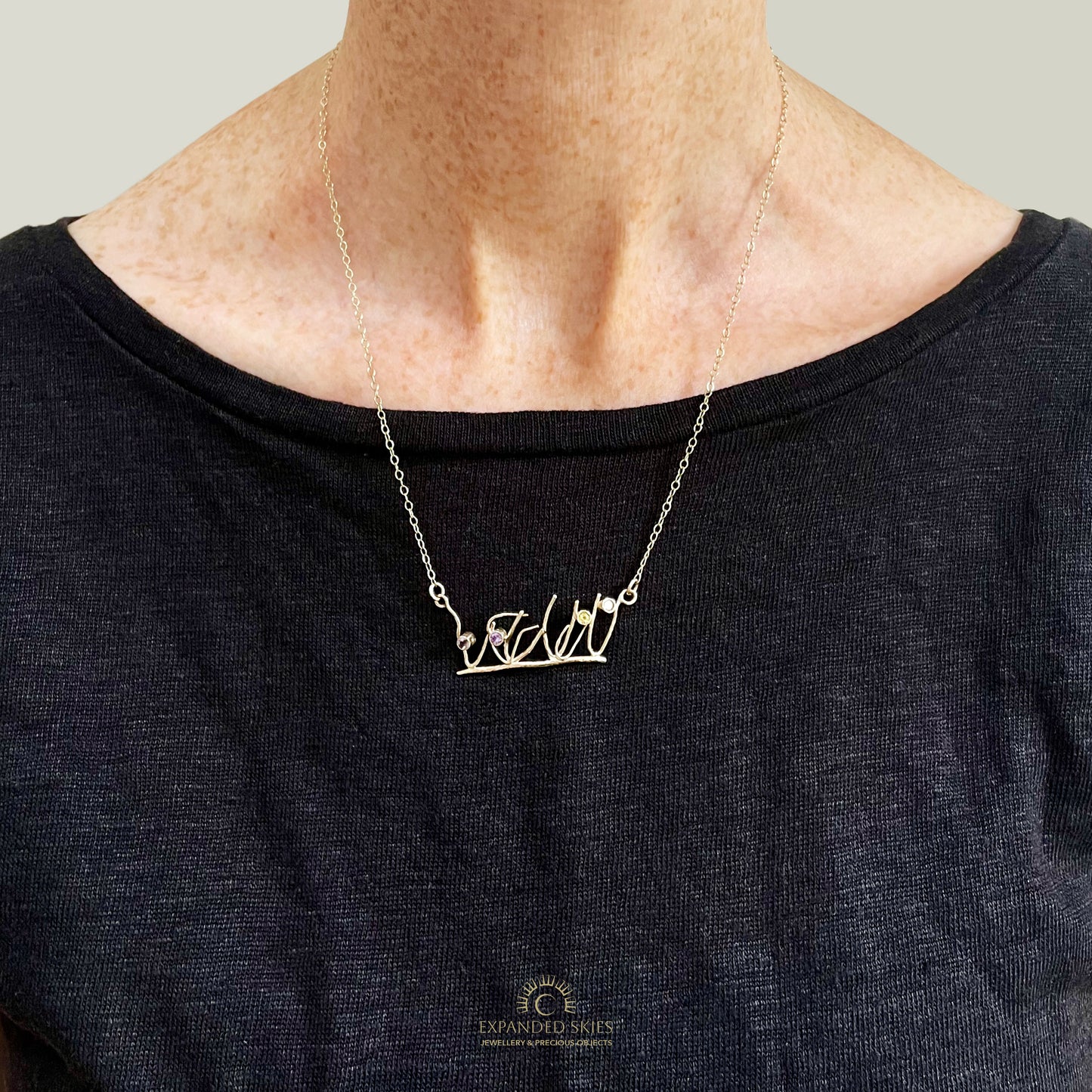 The Expanded Skies Dartmoor Heather and Gorse Necklace evokes the beautiful yellows of the gorse and purples of the heather with two ethically sourced yellow sapphires and two amethysts from Nineteen48 Ltd held in twisting branches of 9ct yellow gold. The chain can be worn at two different lengths, this picture shows the longer length.
This handcrafted unique, one-off, piece makes a wonderful gift, celebrating the evocative and joyful colours of Dartmoor.