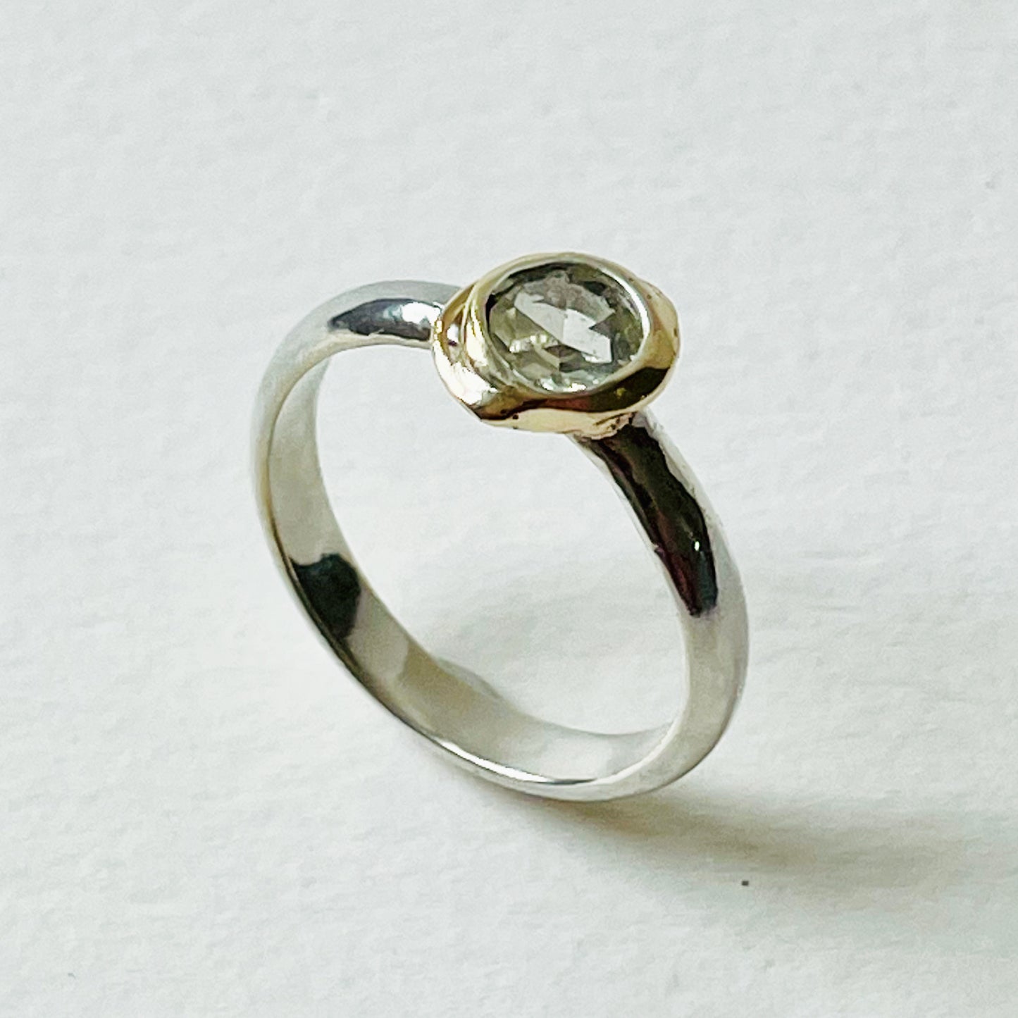 Haytor Quarry Pool White Sapphire Ring has a beautiful ethically sourced Sri Lankan faceted white 5mm sapphire, set in 9ct gold, on sterling silver band. Completely handcrafted from high quality recycled sterling silver and recycled gold. Understated and beautiful, it can be worn every day and for special occasions.