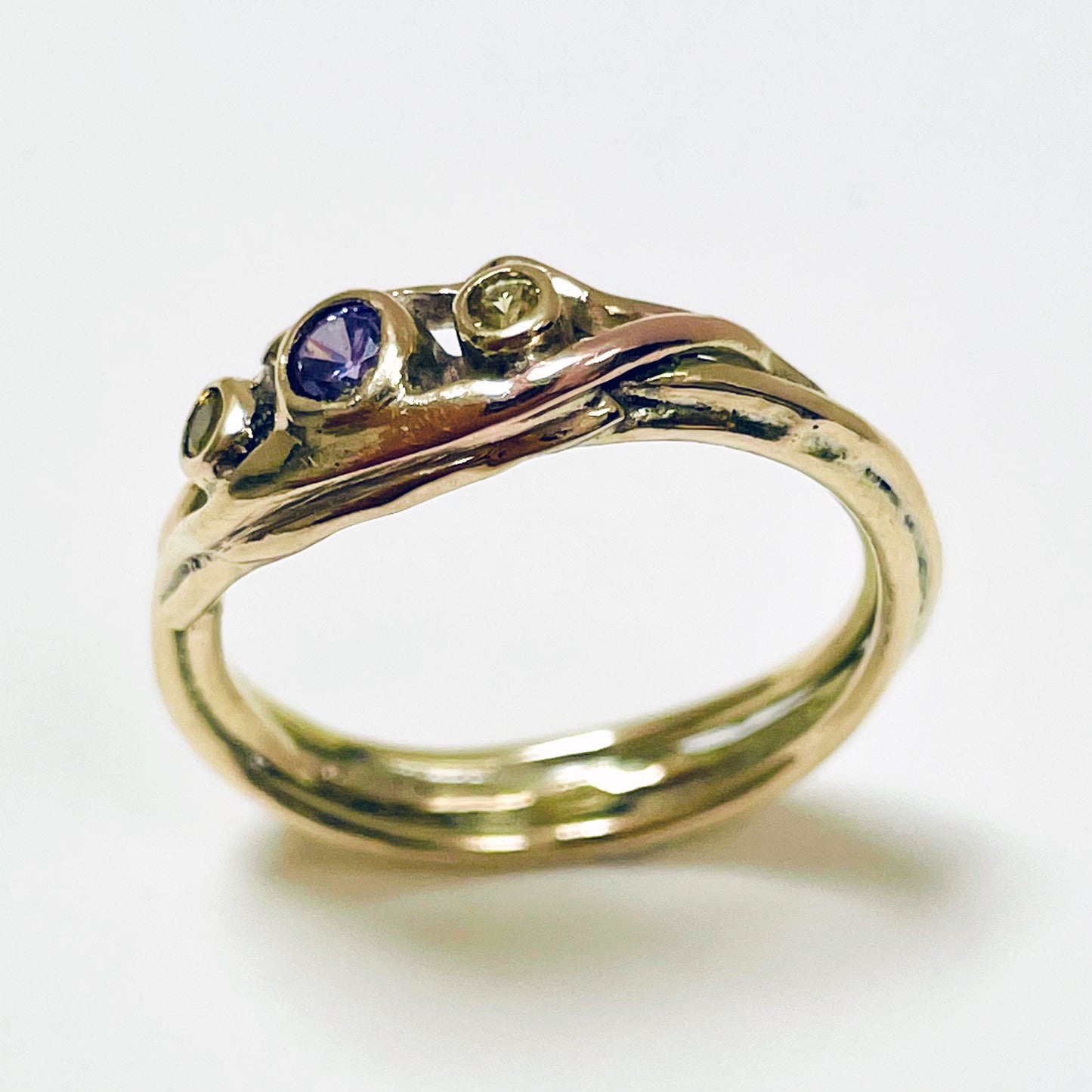 The Haytor Heather and Gorse Ring evokes the beautiful yellows of the gorse and purples of the heather with ethically sourced yellow sapphires and a purple spinel held in three twisting branches of 9ct yellow with accents of 9ct rose gold . This totally handcrafted piece makes a wonderful gift, engagement ring or perfect encapsulation of joy.