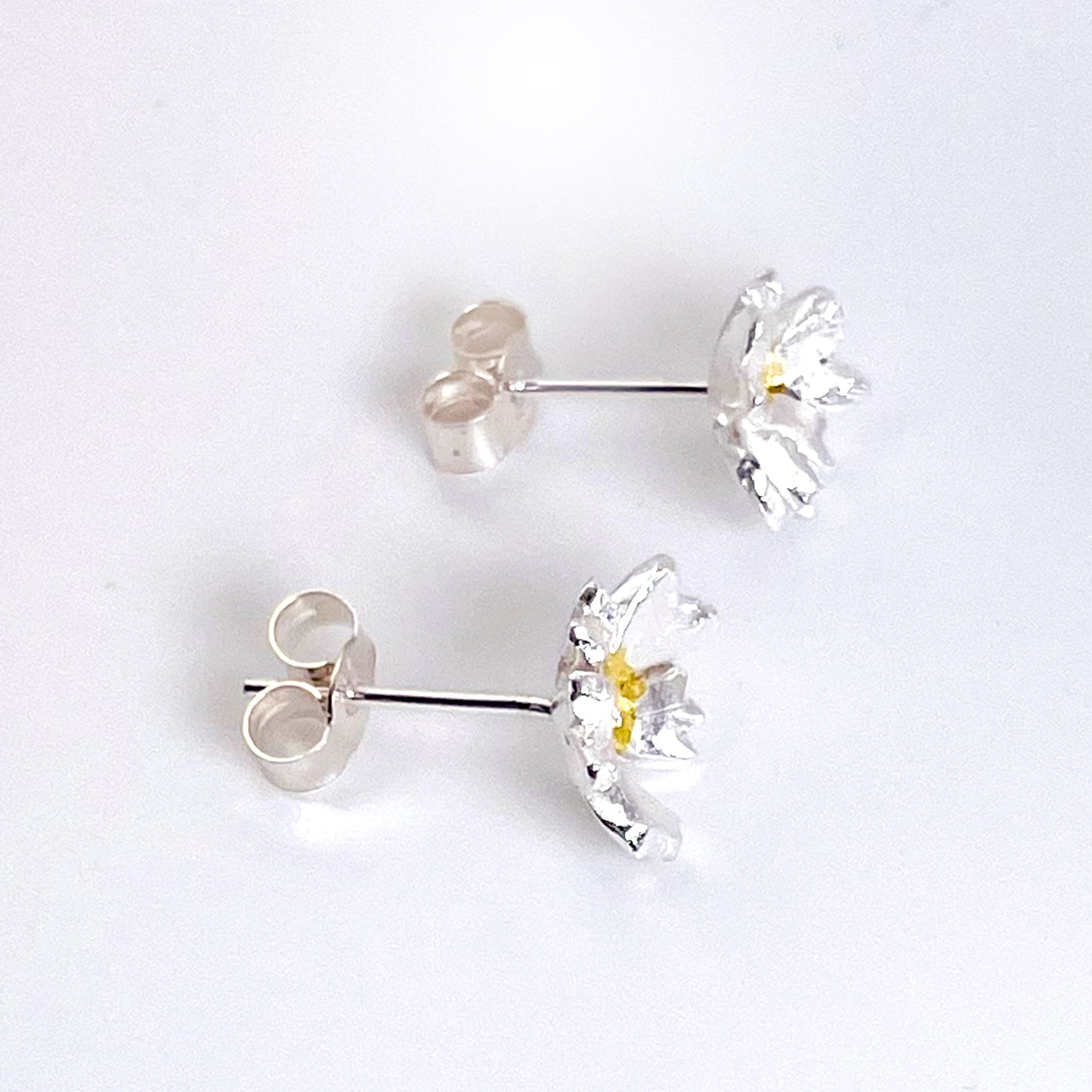 The Expanded Skies Dartmoor Field Rose Studs captures the joyous simple beauty of the field rose, Rosa arvensis, that is seen weaving brightly through the Dartmoor hedgerows and woodland.
Handcrafted in recycled fine silver with recycled 24ct gold accents and recycled sterling silver ear pins and scrolls.