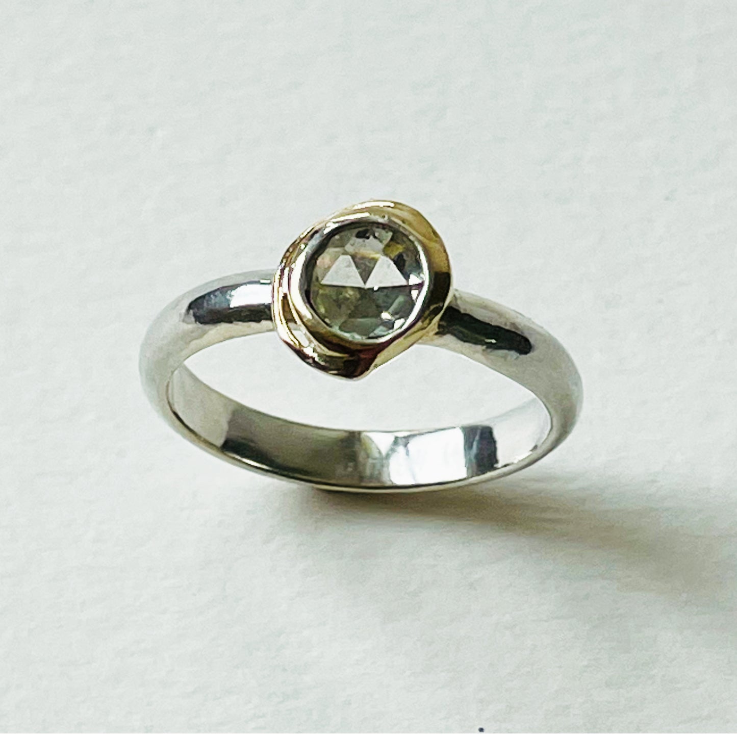 Haytor Quarry Pool White Sapphire Ring has a beautiful ethically sourced Sri Lankan faceted white 5mm sapphire, set in 9ct gold, on sterling silver band. Completely handcrafted from high quality recycled sterling silver and recycled gold. Understated and beautiful, it can be worn every day and for special occasions.