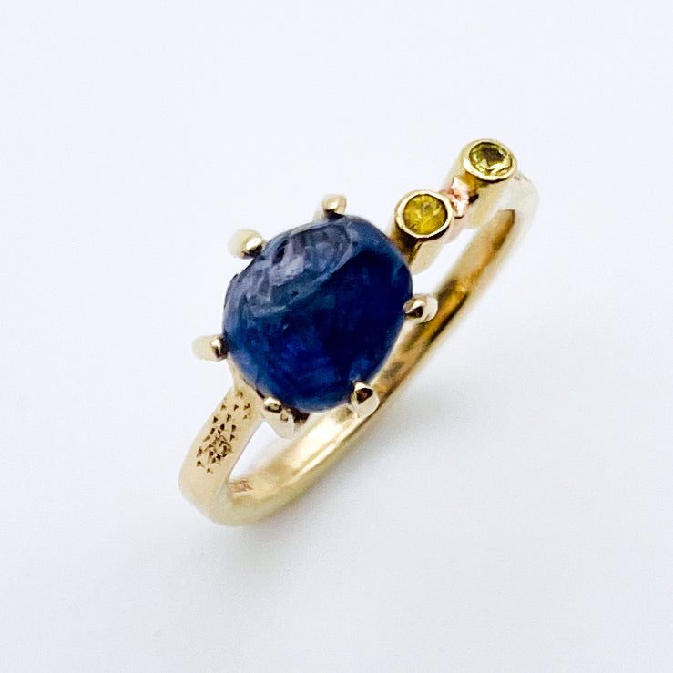 Top view - Side view - the Dartmoor Sun and Skies Sapphire Ring reflects the big Dartmoor skies, the contrasting colours and textures of the moving light over the landscape, created with ethically sourced raw and facetted sapphires and different shades of gold.