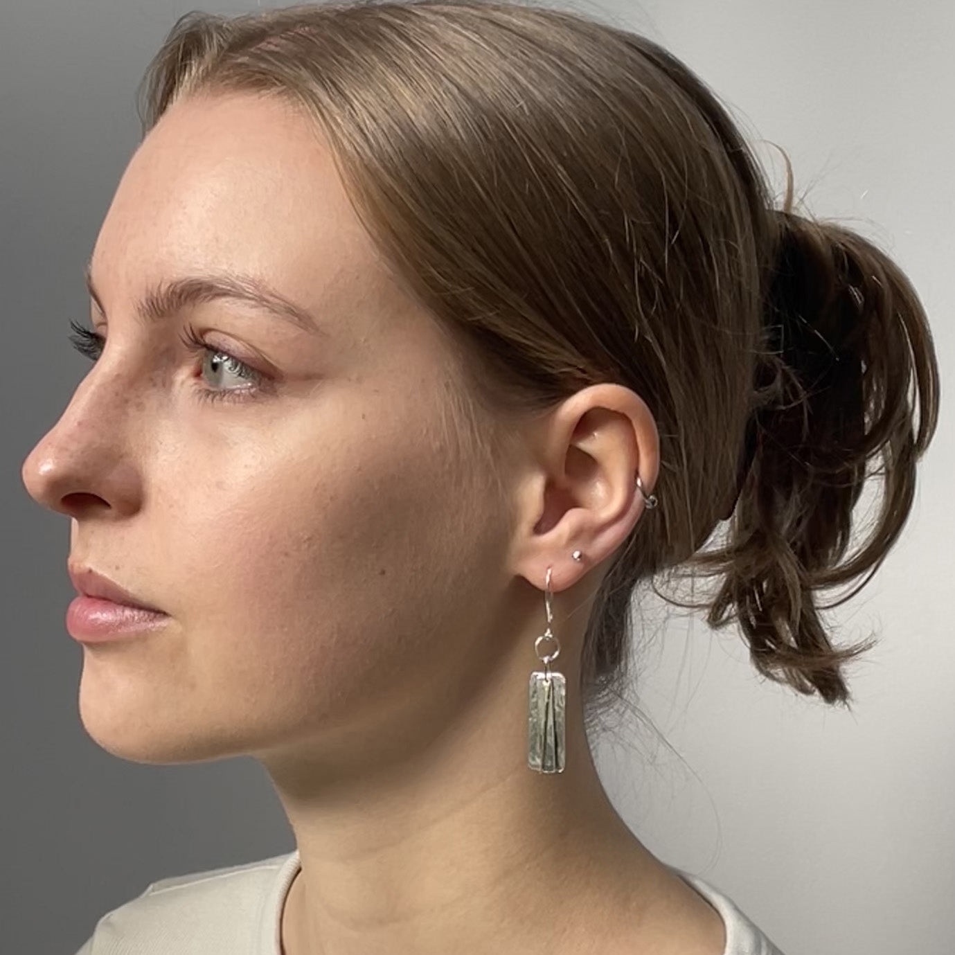 The Dartmoor Dart Valley earrings, are inspired by the River Dart, that viewed from high on top of granite moorland, glints and snakes through the steep sides of the deeply wooded valley. Handcrafted layers of solid recycled sterling silver are hammered and polished with a fine 9ct gold bar, that swing and catch the light.