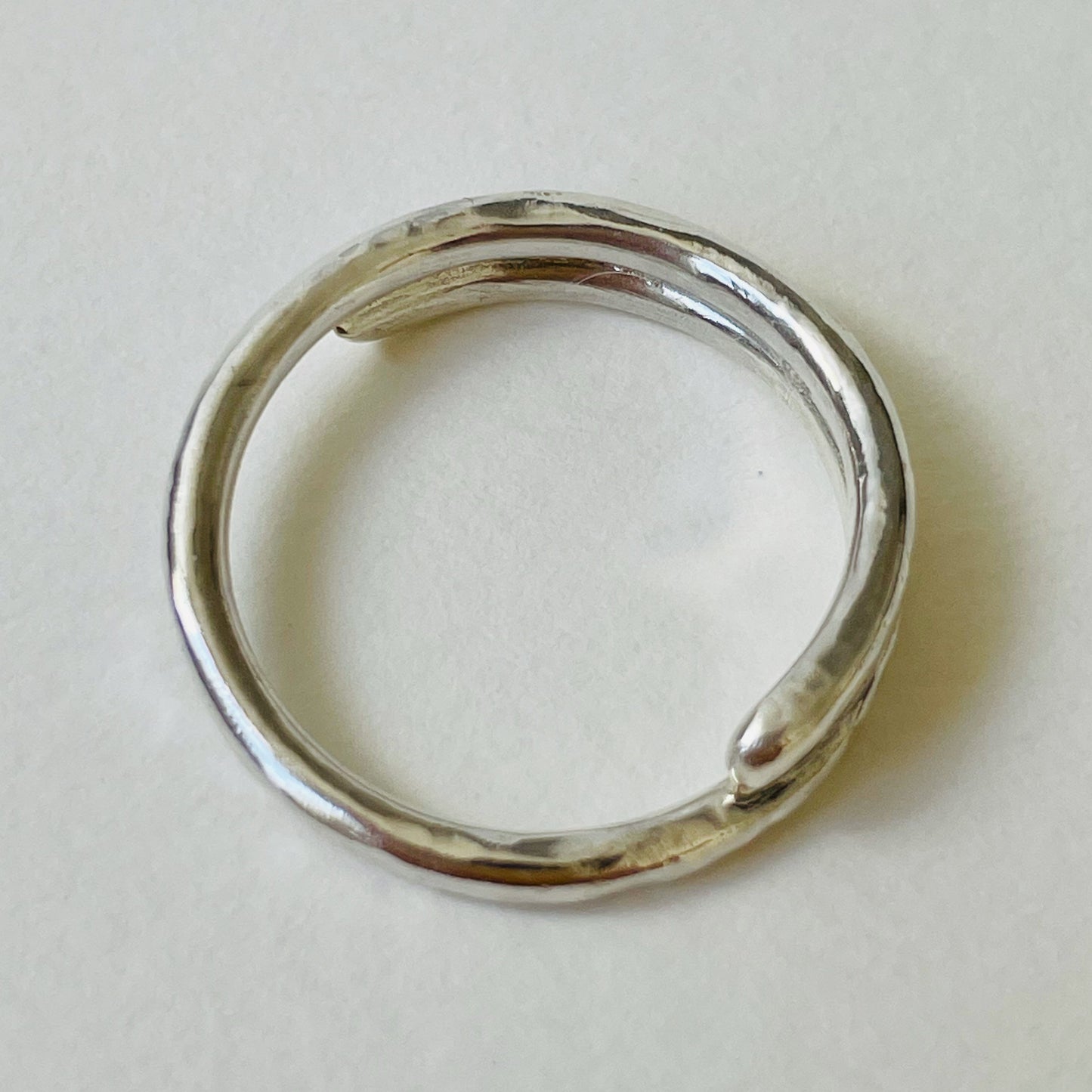 The Dartmoor Dart Valley Hammered Ring, inlaid with 9ct Gold, is inspired by the River Dart, that viewed from high on top of granite moorland, glints and snakes through the steep sides of the deeply wooded valley. The hammered band is handcrafted from a single band of sold sterling recycled silver at back that flows into a recycled 9ct gold band at the front, flanked by two silver bands. Wear everyday, perfect as a wedding ring or to accompany any outfit, understated, beautiful.
