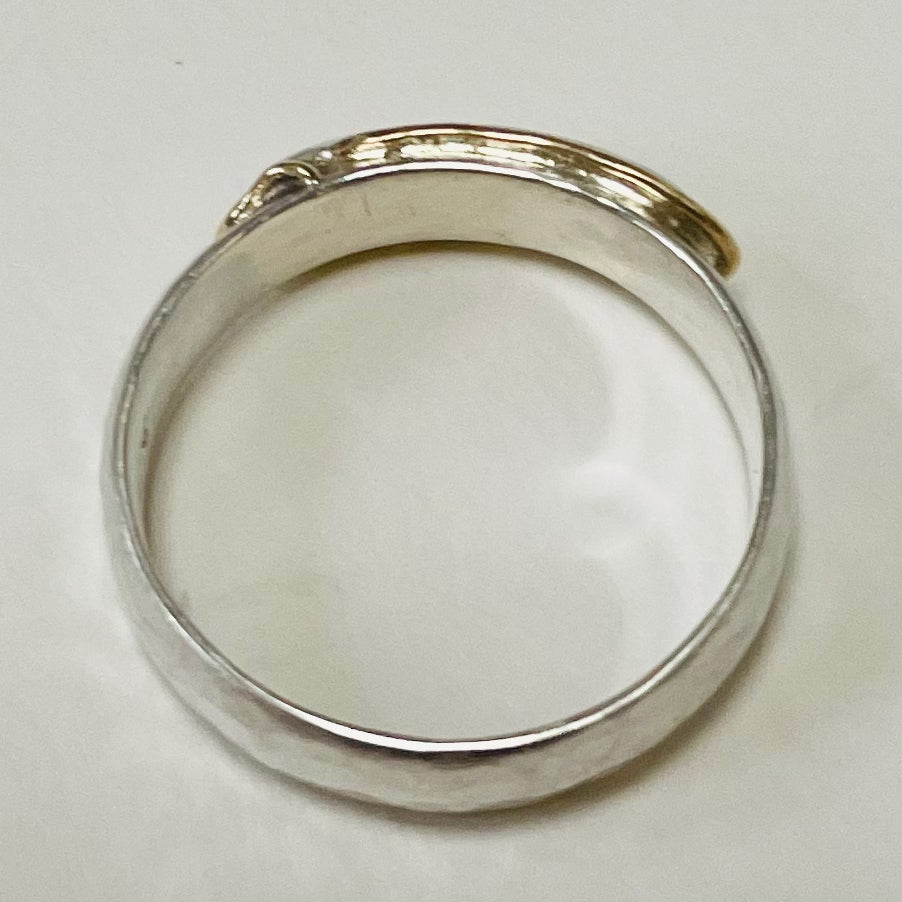 The Dartmoor High Tor Hammered Ring inlaid with 9ct Gold is inspired by the rugged beauty of the granite moorland. The band is handcrafted from sold sterling recycled silver. The 'tor' (referring to the mounded rocks on the summit of hills on Dartmoor) is layered with a sterling silver 'tor', inlaid with recycled 9ct Gold.