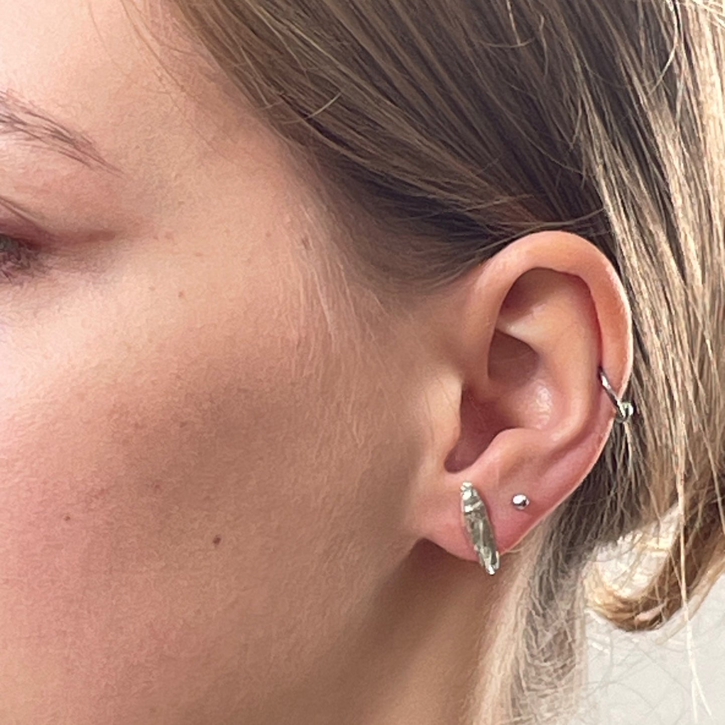 Inspired by the Dartmoor granite rocks abundant with large quartz crystals, megacrysts. The Dartmoor Megacryst Studs are handcrafted in recycled fine silver with recycled sterling silver ear pins and scrolls, each megacryst is unique. Simple and elegant with a textured finish, they can be worn everyday for any occasion.
