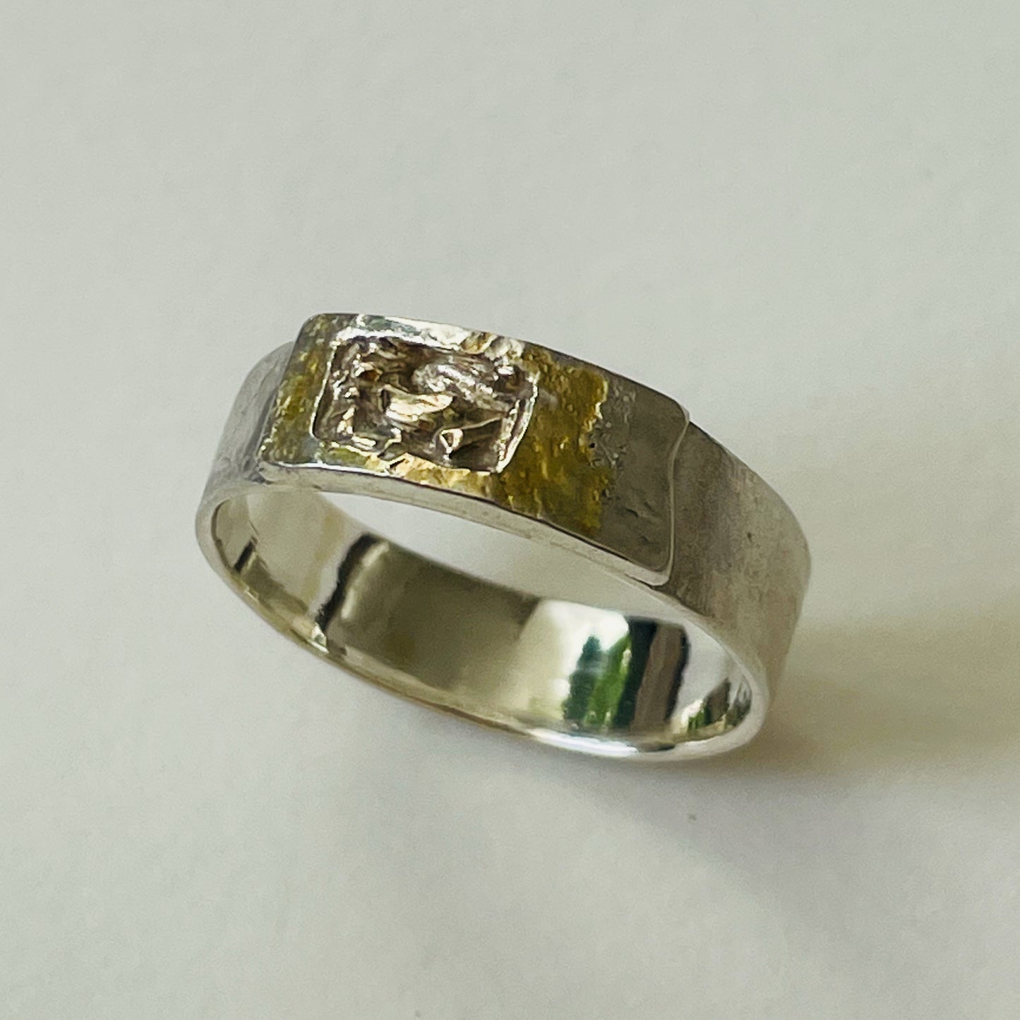 Inspired by the Dartmoor granite rocks abundant with large quartz crystals, megacrysts.
The substantial Dartmoor Megacryst ring is made from recycled sterling silver and recycled 9ct gold. A hammered textured Matt finish on the outer surface and a high polish inside.
The band is handcrafted from sold sterling recycled silver. The 'tor' (referring to the mounded rocks on the summit of hills on Dartmoor) is layered with a sterling silver 'tor', inlaid with recycled 9ct Gold.