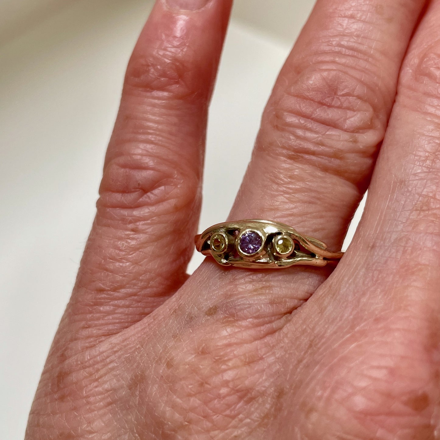 The Haytor Heather and Gorse Ring evokes the beautiful yellows of the gorse and purples of the heather with ethically sourced yellow sapphires and a purple spinel held in three twisting branches of 9ct yellow with accents of 9ct rose gold . This totally handcrafted piece makes a wonderful gift, engagement ring or perfect encapsulation of joy.