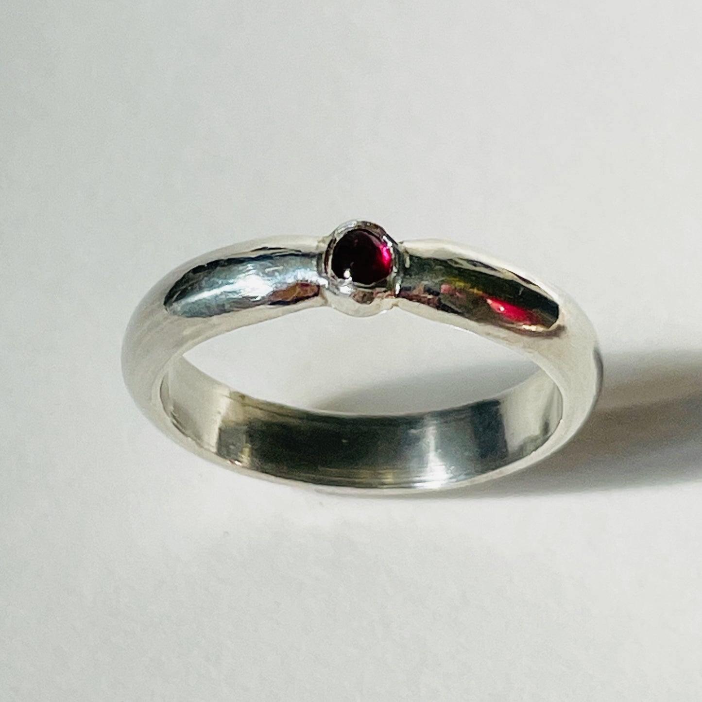 The Ruby-Joy Ring is has a hint of the 1950's exuberance of pinched waists and wide skirts, with a tapering silver band that clasps the oval lustrous pink-red ethically sourced Greenland ruby. With a timeless elegance that can be worn everyday or for special occasions. Dimensions: 2mm D-shaped recycled sterling silver band 4mm x 3mm approx Ethically Mined Greenland Ruby