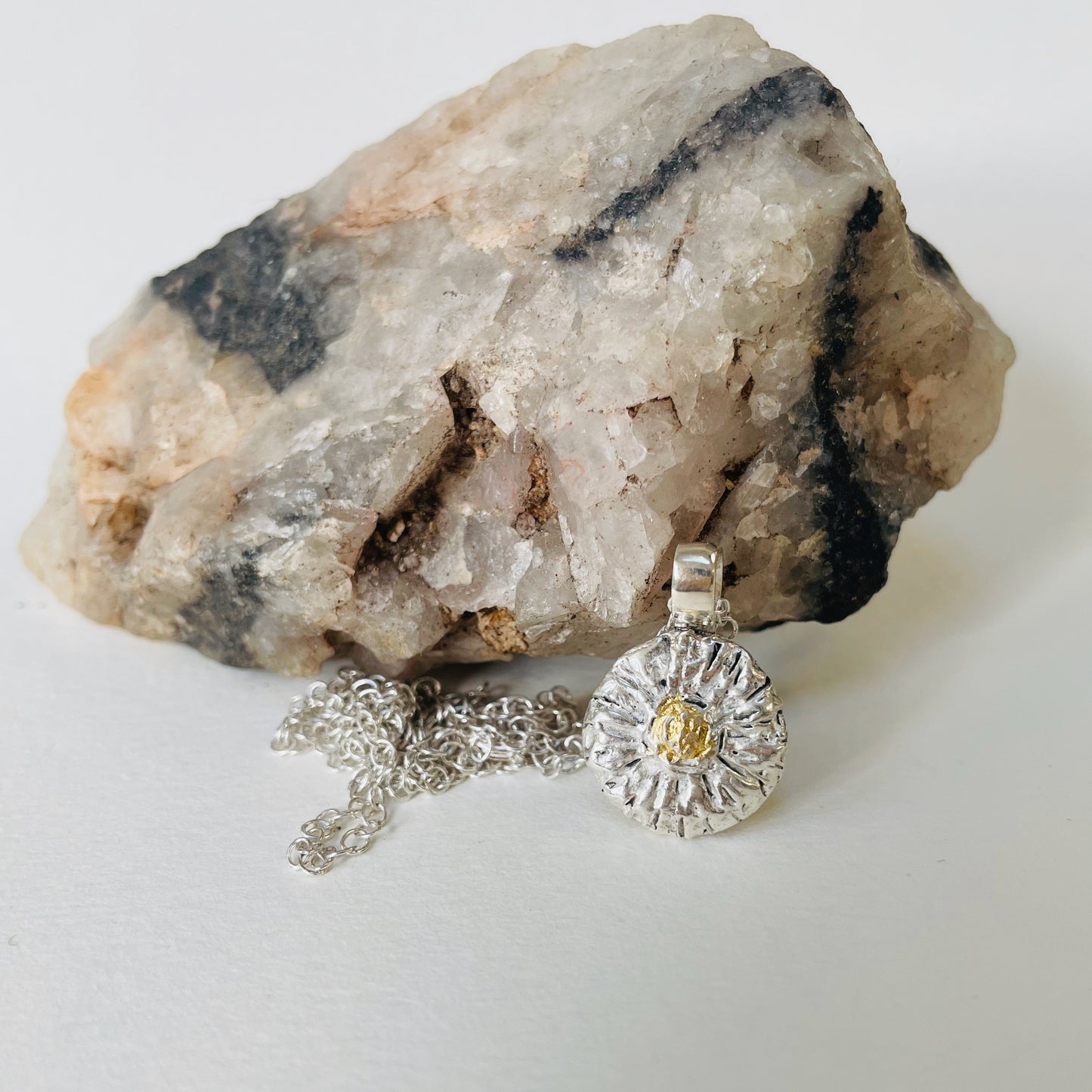 The Expanded Skies Michaelmas Daisy Pendant is totally handcrafted in 100% recycled fine silver (999) with 22ct gold. It has a textured surface that has a twinkly beauty all of its own. 22ct heavy gold foil is applied using keum boo, a traditional Korean gilding technique, that uses heat and pressure, which makes each piece unique. It can be worn every day or for more formal occasions.
