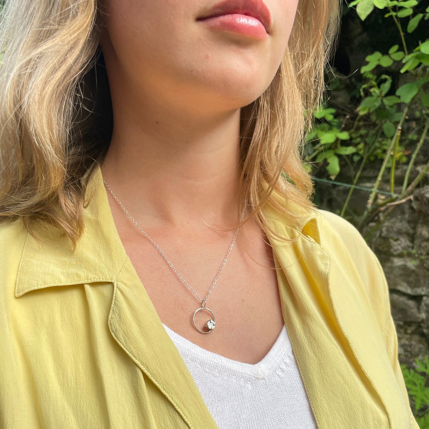 The Moon Light White Sapphire pendant sparkles as its facets reflects the light. The beautiful 5mm rose cut ethically mined Sri Lankan white sapphire has a handcrafted four claw setting on a hammered silver sterling silver band. Understated and beautiful, it can be worn everyday or for special occasions. The pendant comes with a 1.7mm recycled sterling silver trace chain