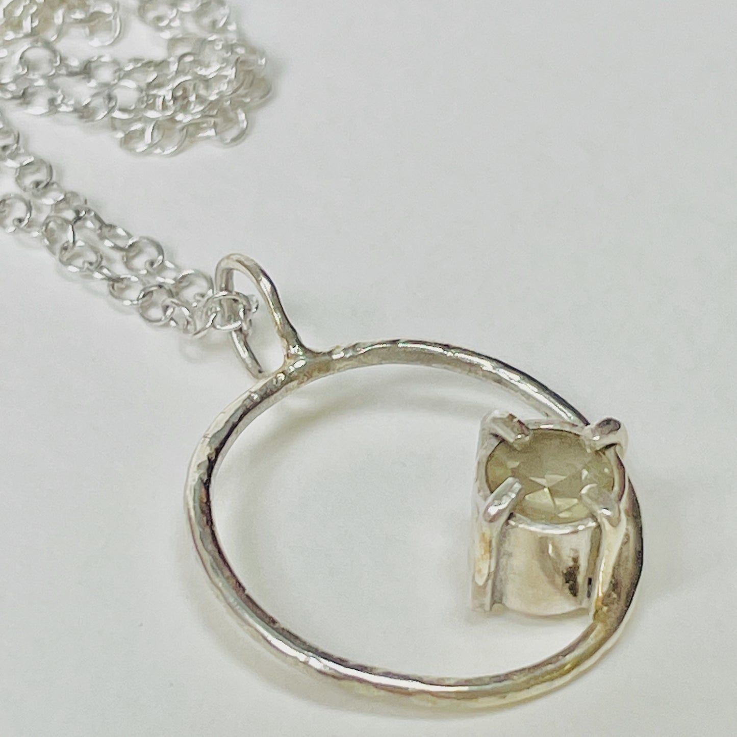 The Moon Light White Sapphire pendant sparkles as its facets reflects the light. The beautiful 5mm rose cut ethically mined Sri Lankan white sapphire has a handcrafted four claw setting on a hammered silver sterling silver band. Understated and beautiful, it can be worn everyday or for special occasions. The pendant comes with a 1.7mm recycled sterling silver trace chain