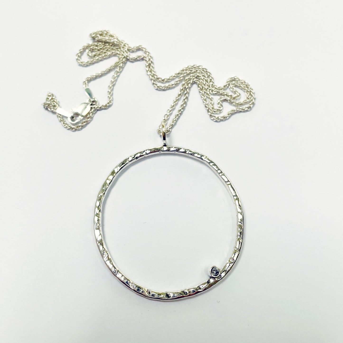 Moonbeam White Sapphire Pendant is totally handcrafted. The delicate 2mm ethically mined, Sri Lankan white sapphire is set on a hammered silver sterling silver band, made from high quality recycled sterling silver. Understated and beautiful, it can be worn everyday or for special occasions.