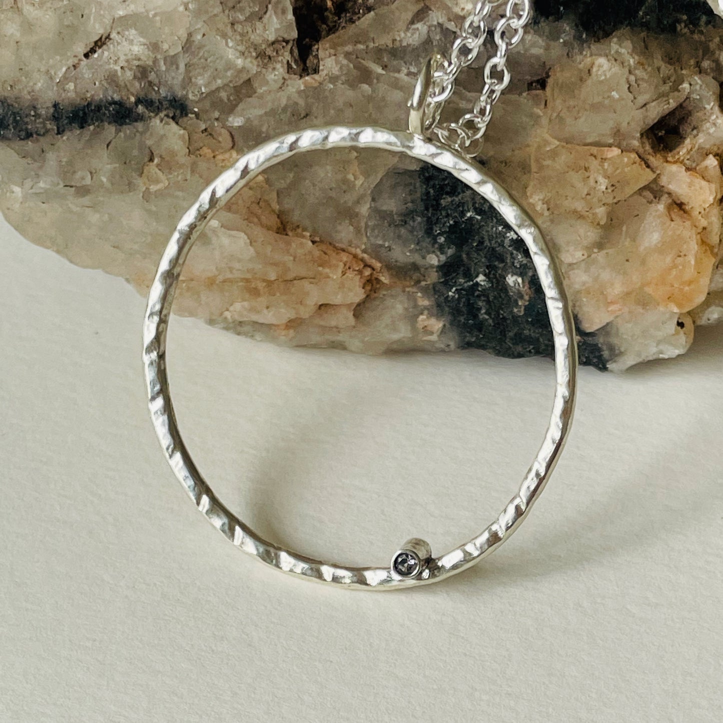 Moonbeam White Sapphire Pendant is totally handcrafted. The delicate 2mm ethically mined, Sri Lankan white sapphire is set on a hammered silver sterling silver band, made from high quality recycled sterling silver. Understated and beautiful, it can be worn everyday or for special occasions.