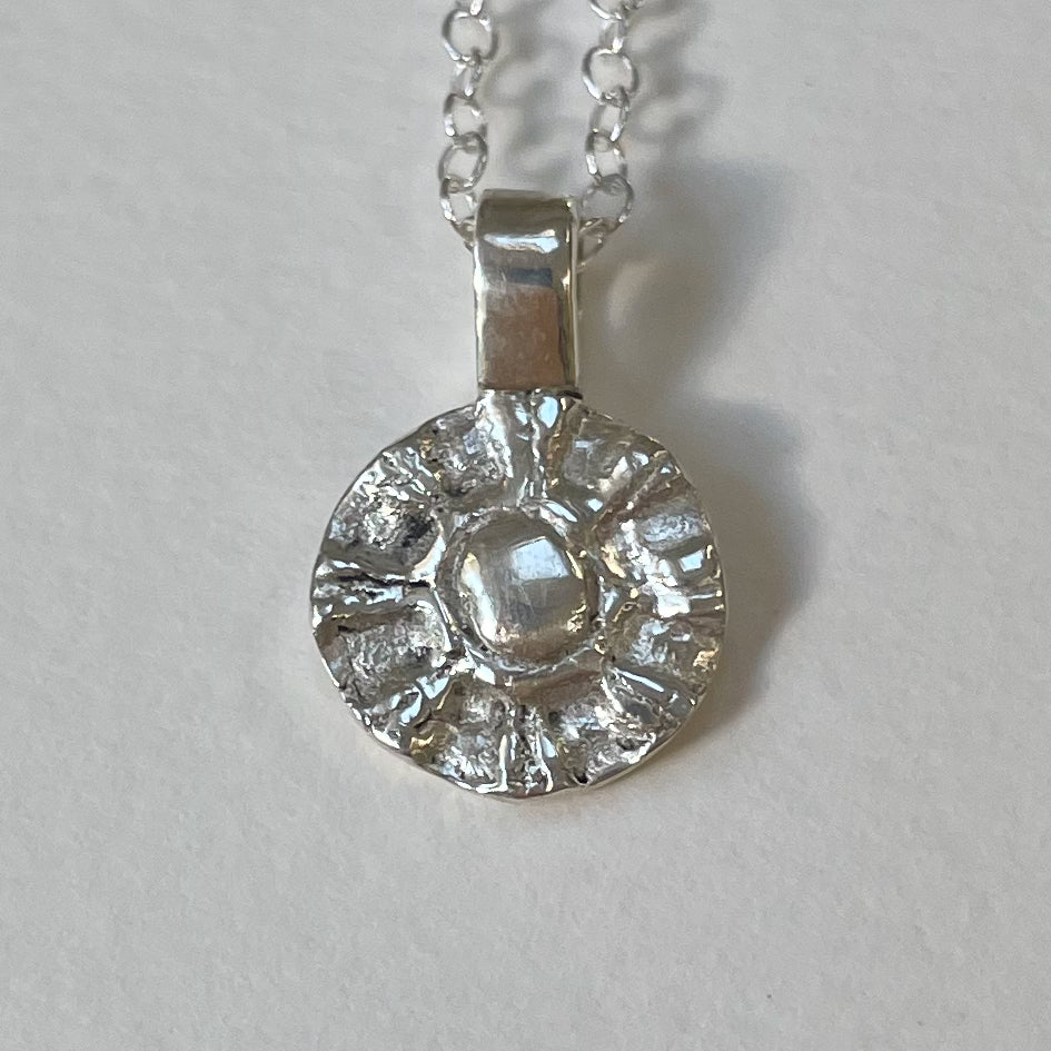 The Radiant Sun Pendant is joyful! Hand sculpted in recycled solid fine silver (999) with a textured surface with a twinkly beauty. It can be worn everyday or as a beautiful detail on more formal occasions.
