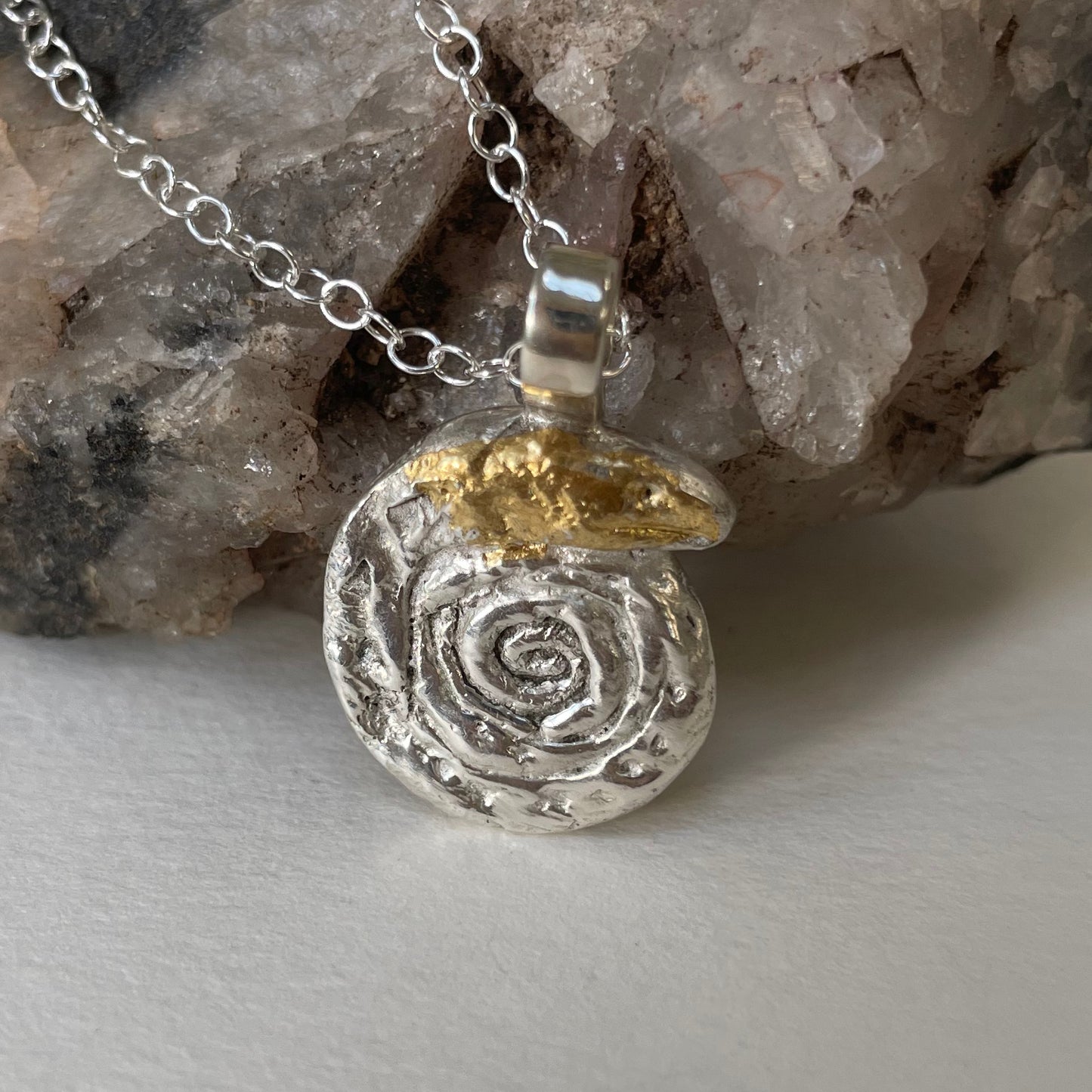 The Expanded Skies Spiral Snake pendant is totally handcrafted in 100% recycled fine silver (999) with 22ct gold. It has a textured surface that has a twinkly beauty all of its own. 22ct heavy gold foil is applied using keum boo, a traditional Korean gilding technique, that uses heat and pressure, which makes each piece unique. It can be worn every day or for more formal occasions