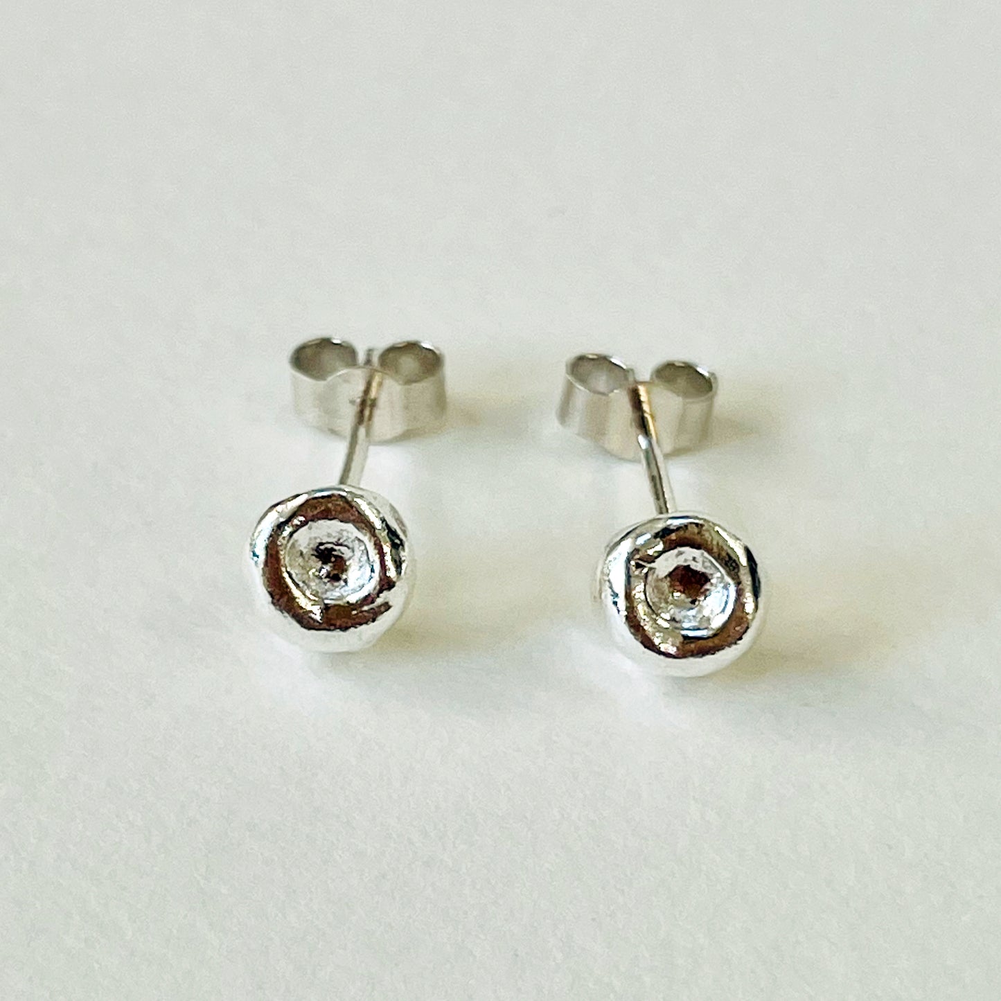Inspired by the sculptural beauty of the Dartmoor granite rocks. The Dartmoor Rocks Studs are handcrafted in recycled fine silver with recycled sterling silver ear pins and scrolls, each stud is unique. Simple and elegant with a textured finish, and a polished finish they can be worn everyday for any occasion.