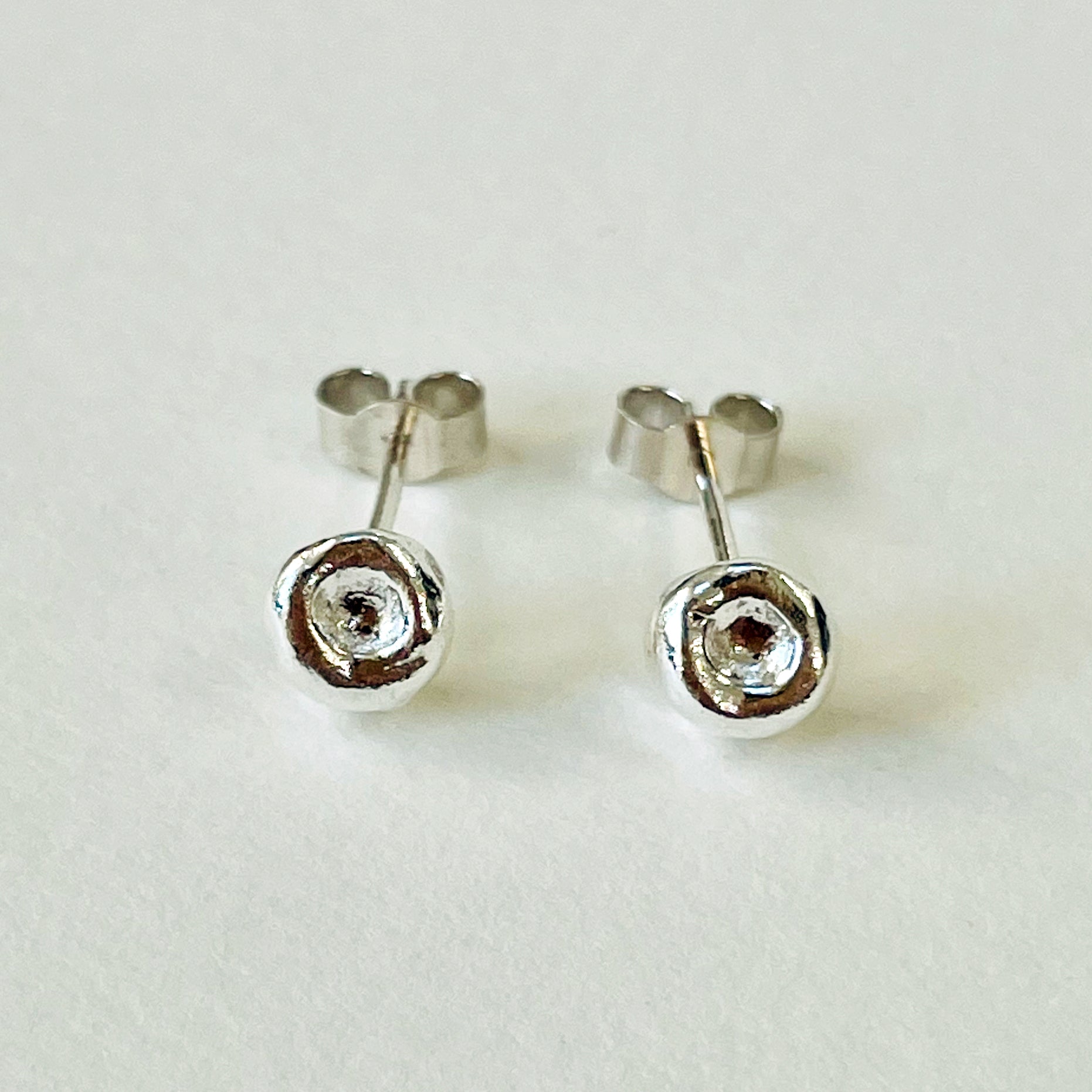 Inspired by the sculptural beauty of the Dartmoor granite rocks. The Dartmoor Rocks Studs are handcrafted in recycled fine silver with recycled sterling silver ear pins and scrolls, each stud is unique. Simple and elegant with a textured finish, and a polished finish they can be worn everyday for any occasion.