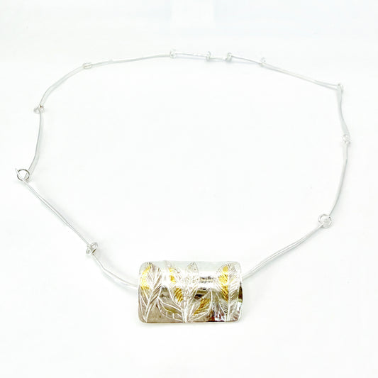 The Expanded Skies Dartmoor Wild Honeysuckle Leaves Necklace is a hand engraved of the graceful honeysuckle (Lonicera periclymenum) as it winds through the trees and brambles in Ausewell Woods. Handcrafted in fine silver with 24ct gold accents, with a completely handcrafted stem and tendril chain in sterling silver. Simple and elegant with a polished finish, it can be worn everyday for any occasion.