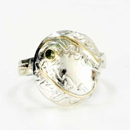 Expanded Skies Two Dartmoor Oak Leaves Sapphire Ring is inspired by the beautiful oak seedlings in Hembury Woods created in recycled sterling and fine silver, inlaid with 9ct gold with an ethically sourced Australian green sapphire set in 9ct gold, with hand engraved oak leaves.