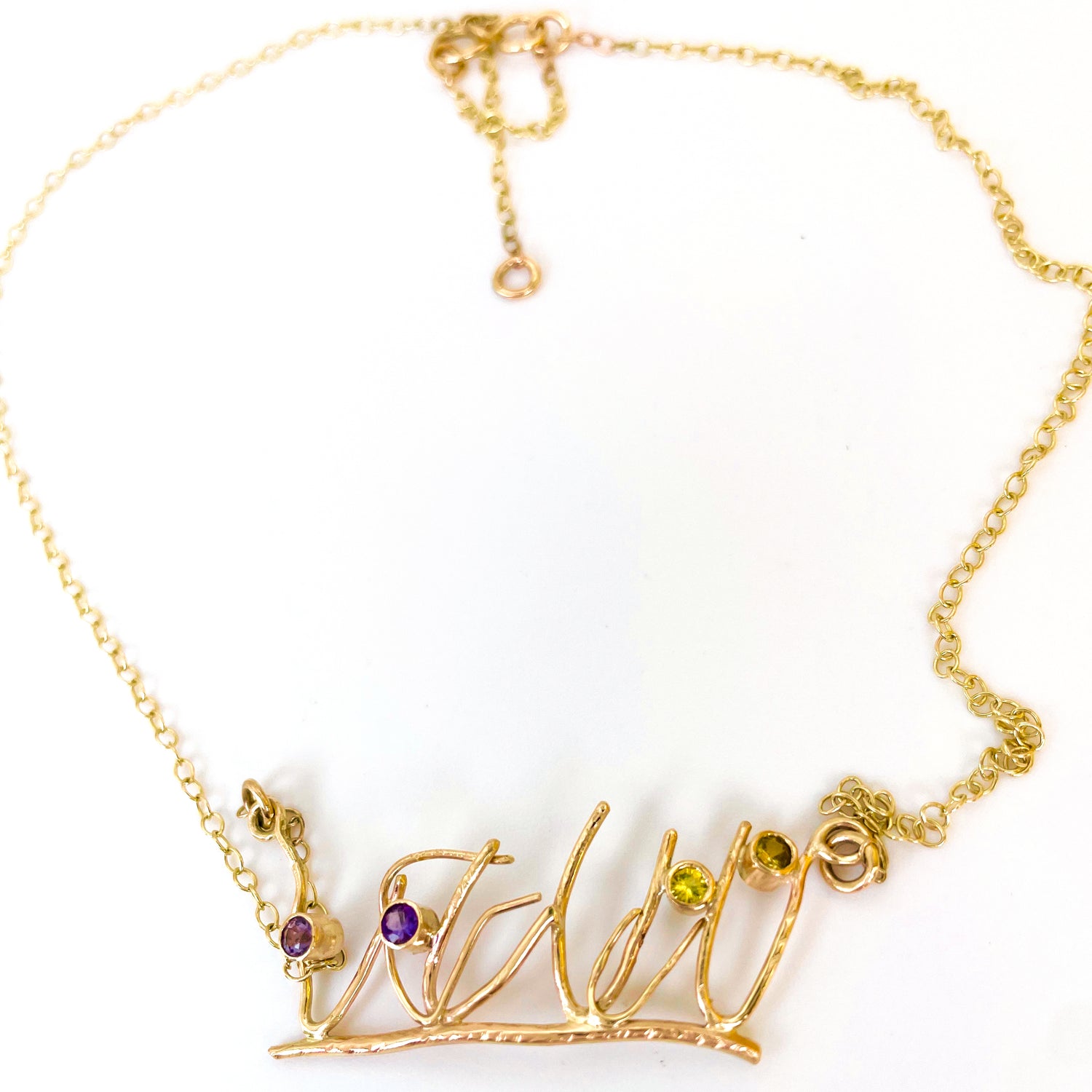 The Expanded Skies Dartmoor Heather and Gorse Necklace evokes the beautiful yellows of the gorse and purples of the heather with two ethically sourced yellow sapphires and two amethysts from Nineteen48 Ltd held in twisting branches of 9ct yellow gold. The chain can be worn at two different lengths, this picture shows the longer length.
This handcrafted unique, one-off, piece makes a wonderful gift, celebrating the evocative and joyful colours of Dartmoor.