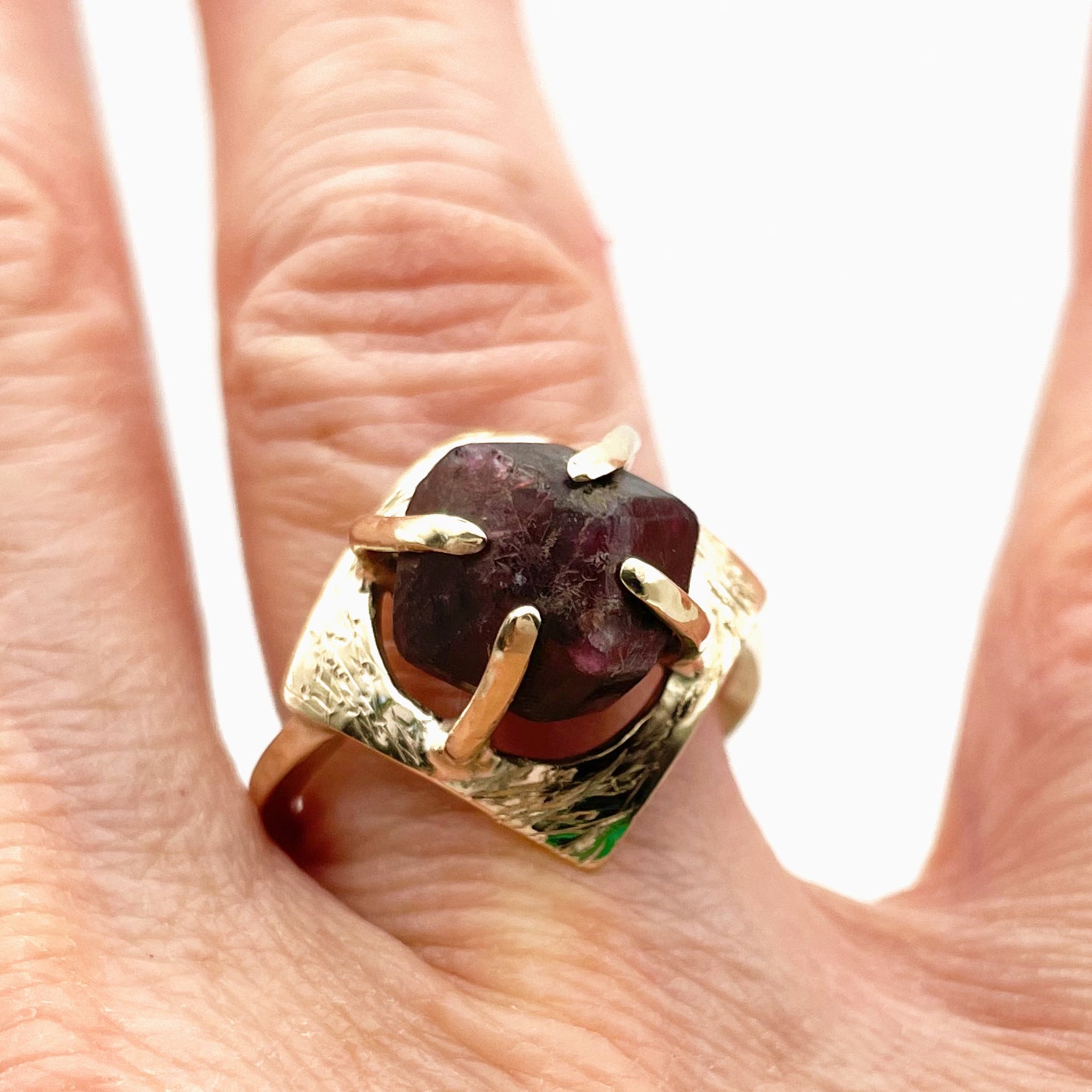 The Expanded Skies Heaven and Earth Raw Garnet Ring has a beautiful raw Norwegian garnet set in 9ct gold. The garnet is set in a distinctive completely handcrafted engraved claw setting. This is a unique piece, one-of-a-kind. Handcrafted on the edge of Dartmoor and made from high quality recycled gold, Hallmarked by the London Assay Office.