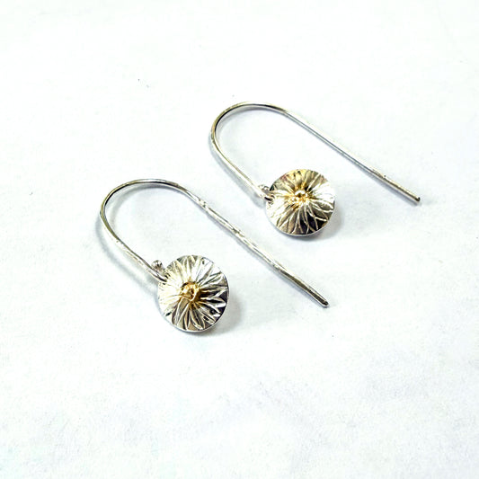 Dartmoor Daisy Hand Engraved Drop Earrings with 24ct Gold Accents are inspired by the daisies (Erigeron Karvinskianus), commonly known as the 'Dartmoor Daisy', that speckle granite walls along the lanes and waysides, bringing lightness and joy to the walker.

Handcrafted in recycled fine silver with recycled 24ct gold accents and sterling silver ear wires. Each earring is hand engraved and is unique. Simple and elegant with a textured finish, and a polished finish they can be worn everyday for any occasion.