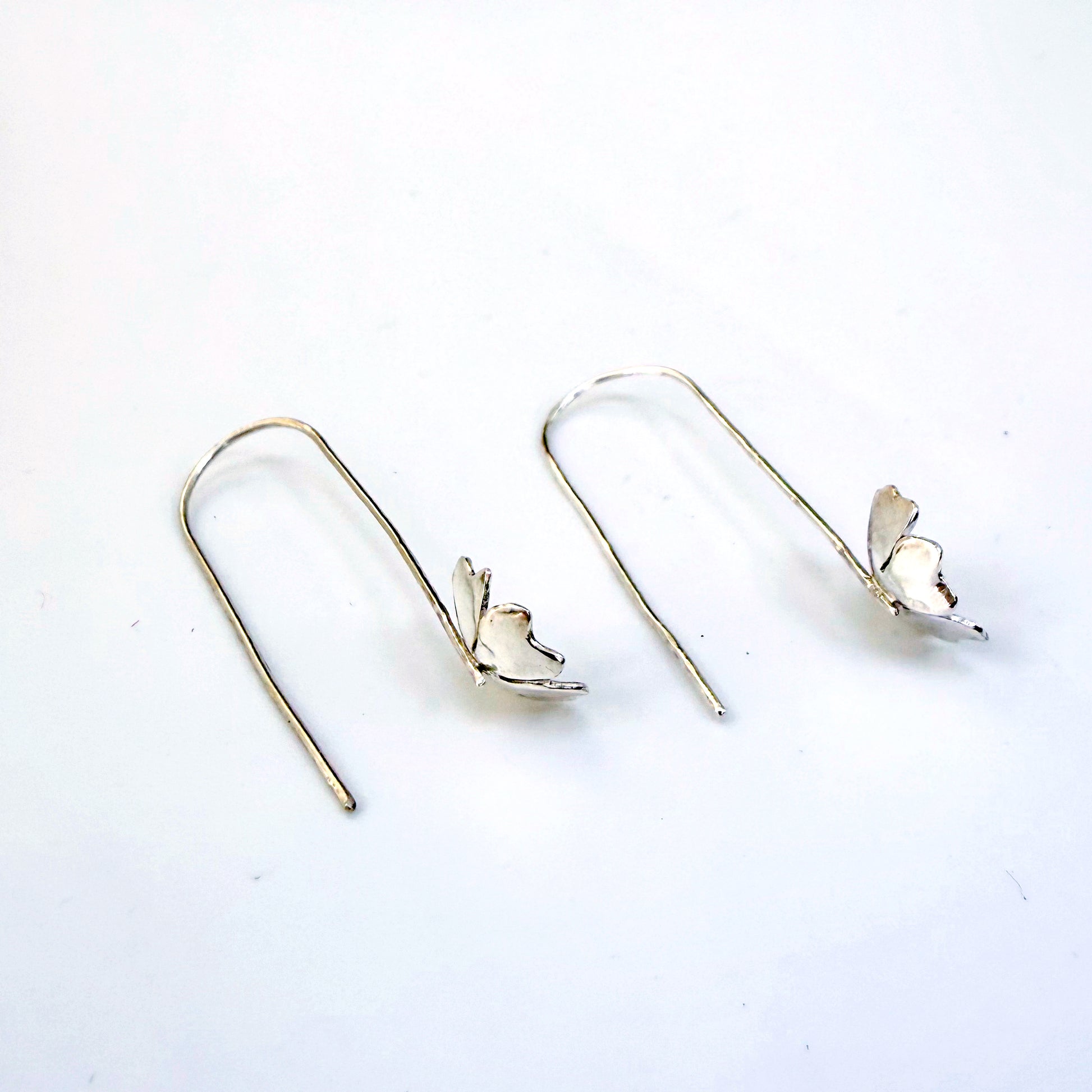 The Expanded Skies Dartmoor Field Rose Drop Earrings capture the joyous simple beauty of the field rose, Rosa arvensis, that is seen weaving brightly through the Dartmoor hedgerows and woodland. Hand pierced and formed in recycled fine silver with recycled 24ct gold accents and recycled sterling silver ear wires. 