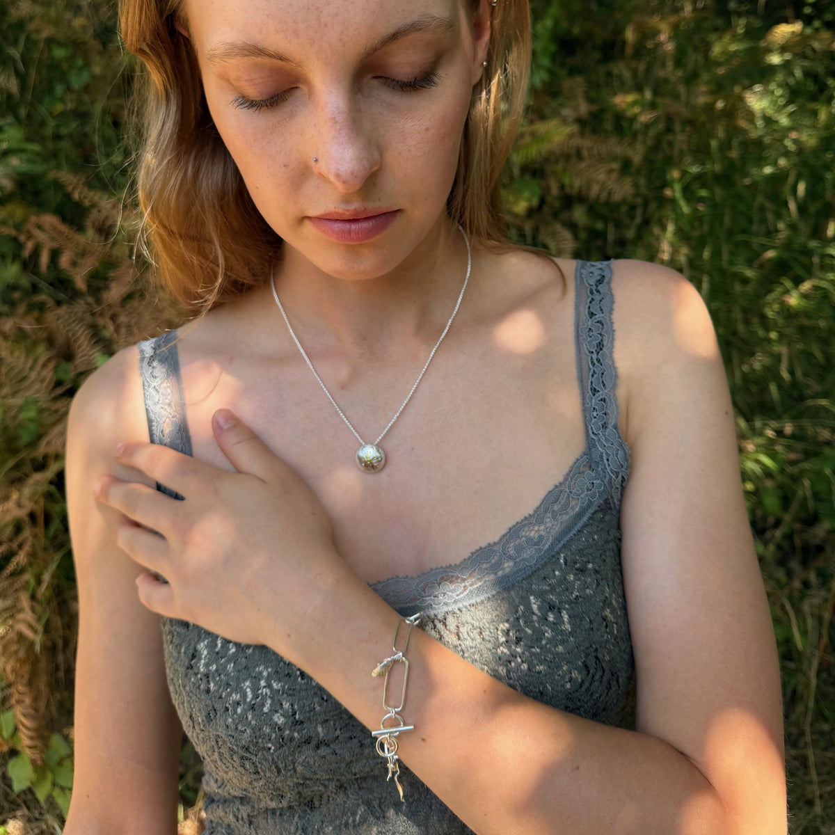 The Expanded Skies Dartmoor Field Rose Bracelet pictured with The Expanded Skies Dartmoor Field Rose necklace captures the joyous beauty of the field rose, Rosa arvensis, seen weaving brightly through the Dartmoor hedgerows and woodland. The bracelet’s rose and leaves are hand engraved and has a painterly feel, accented with 24ct gold.