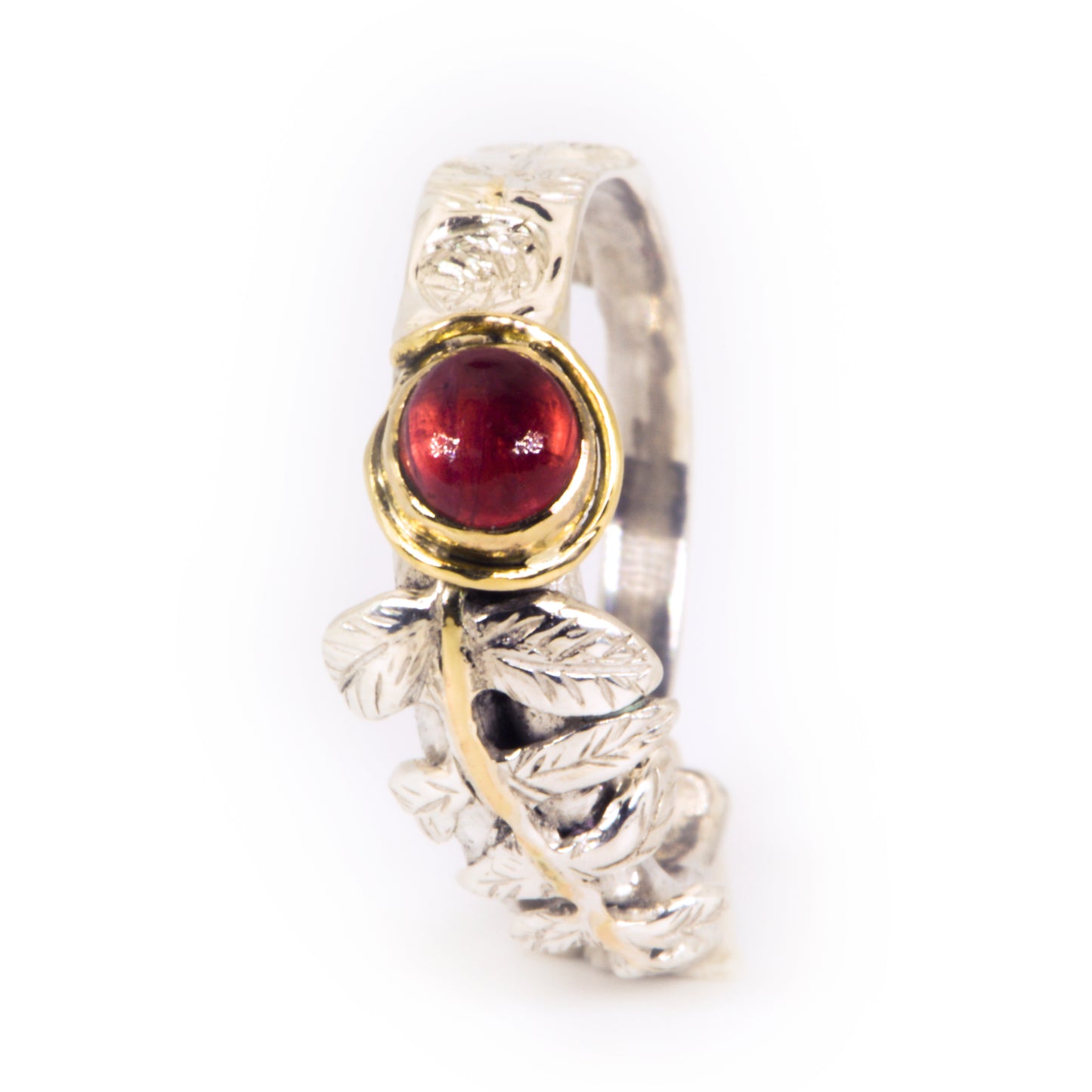 
Expanded Skies Dartmoor Rowan Leaf and Berries Spinel Ring. The Expanded Skies Dartmoor Rowan Leaf and Berries Spinel Ring is totally handcrafted on the edge of Dartmoor. The ring is created in recycled sterling silver, inlaid with 9ct gold. The ring is set with an ethically sourced Tanzanian red-pink spinel, set in 9ct gold, with a hand formed rowan leaf, inlaid with 9ct gold. The ethically sourced 4.5mm round spinel is from Moyo Gems. Moyo gems is run by female miners Tanzanian Women Miners' Association.