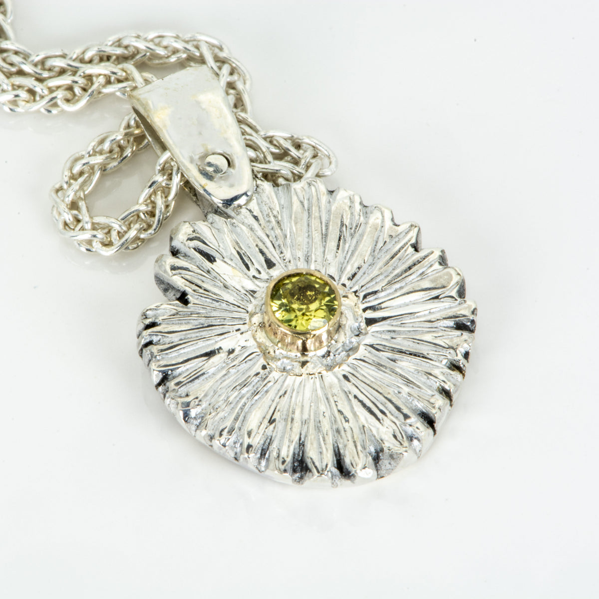 The Expanded Skies Dartmoor Daisy Sapphire Necklace in sterling silver and 9ct gold is inspired by the Erigeron Karvinskianus, commonly known as the 'Dartmoor Daisy'. It comes with 16” Italian spiga rolled chain, made from recycled sterling silver. The daisy pendant measures 12mm, the bail measures 6mm, total length 18mm with a depth of 2mm (approx). Each piece is individually saw pierced, hand engraved and
unique. The ethically sourced 2.5mm yellow sapphire is from Queensland, Australia.