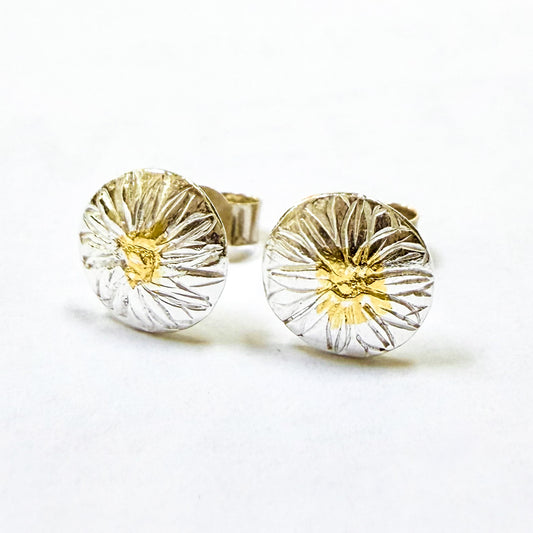 The Expanded Skies Dartmoor Daisy Studs are inspired by the daisies (Erigeron Karvinskianus), commonly known as the 'Dartmoor Daisy', that speckle granite walls along the lanes and waysides, bringing lightness and joy to the walker.

Handcrafted in recycled fine silver with recycled 24ct gold accents and sterling silver ear pins and scrolls. Each stud is unique. Simple and elegant with a textured finish, and a polished finish they can be worn everyday for any occasion.
