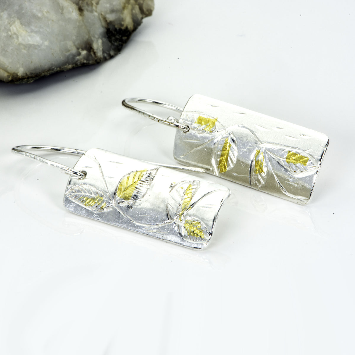 The Expanded Skies Dartmoor Honeysuckle Leaves Drop Earrings are hand engravings of the graceful honeysuckle (Lonicera periclymenum) as it winds through the trees and brambles in Ausewell Woods.

Handcrafted in recycled fine silver with recycled 24ct gold accents with sterling silver ear wires. Each earring’s hand engraving is unique. Simple and elegant with a textured, polished finish, they can be worn everyday for any occasion.

The earrings are totally handcrafted on the edge of Dartmoor and made from hi
