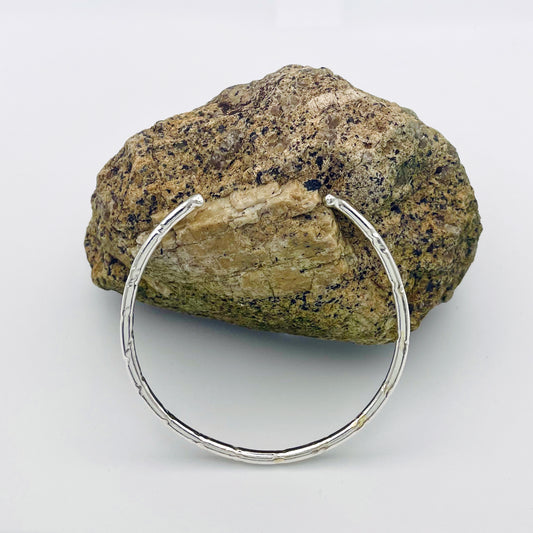 Expanded Skies Dartmoor Torc Bangle combines the classic shape with the textures and hand engraving that evokes the granite landscape. 
The bangle is totally handcrafted on the edge of Dartmoor in the Expanded Skies signature hand-drawn aesthetic. Made from high quality recycled sterling silver. For men and women, simple, beautiful. 
