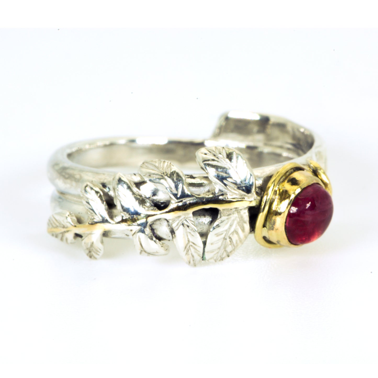 
Expanded Skies Dartmoor Rowan Leaf and Berries Spinel Ring. The Expanded Skies Dartmoor Rowan Leaf and Berries Spinel Ring is totally handcrafted on the edge of Dartmoor. The ring is created in recycled sterling silver, inlaid with 9ct gold. The ring is set with an ethically sourced Tanzanian red-pink spinel, set in 9ct gold, with a hand formed rowan leaf, inlaid with 9ct gold. The ethically sourced 4.5mm round spinel is from Moyo Gems. Moyo gems is run by female miners Tanzanian Women Miners' Association.
