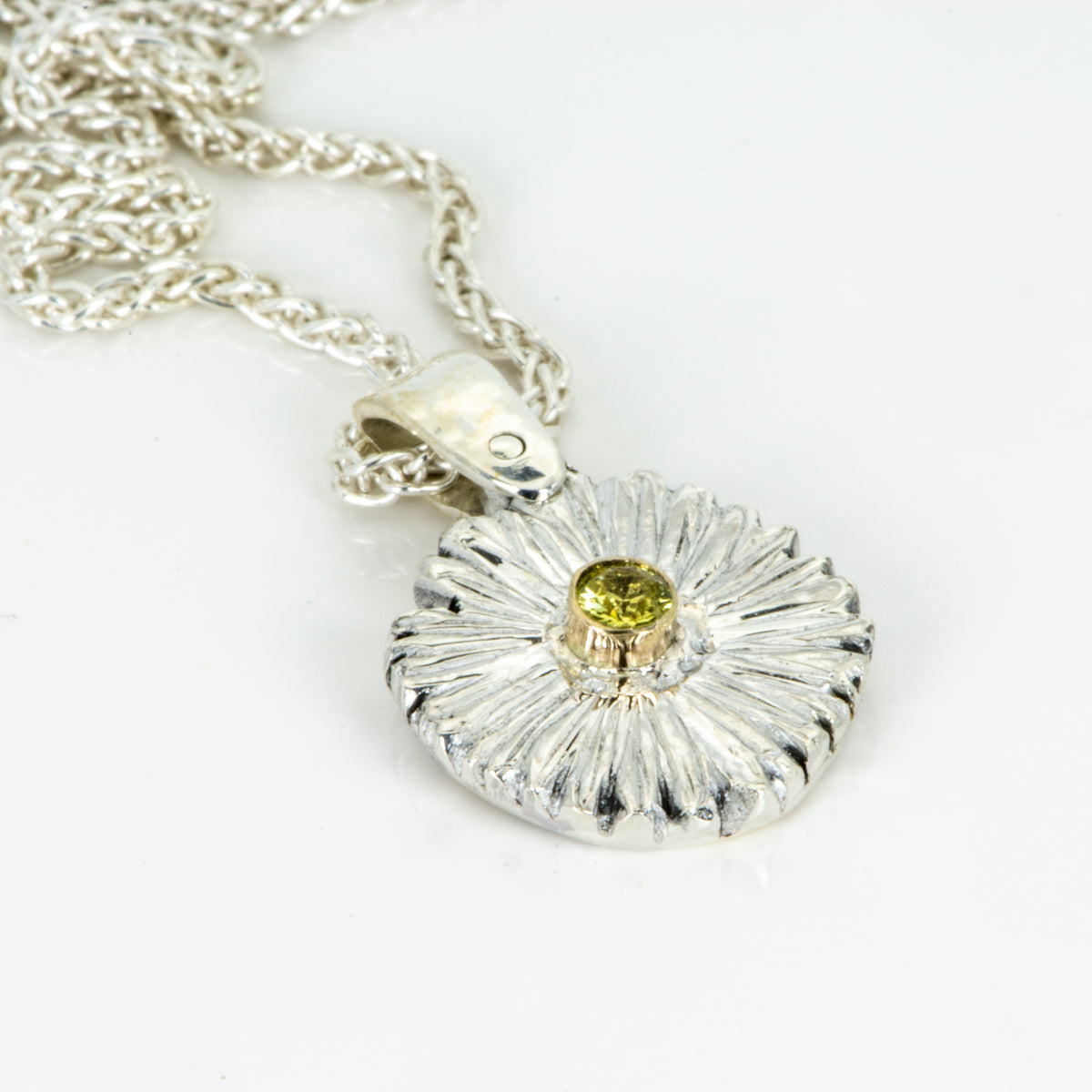 The Expanded Skies Dartmoor Daisy Sapphire Necklace in sterling silver and 9ct gold is inspired by the Erigeron Karvinskianus, commonly known as the 'Dartmoor Daisy'. It comes with 16” Italian spiga rolled chain, made from recycled sterling silver. The daisy pendant measures 12mm, the bail measures 6mm, total length 18mm with a depth of 2mm (approx). Each piece is individually saw pierced, hand engraved and
unique. The ethically sourced 2.5mm yellow sapphire is from Queensland, Australia.