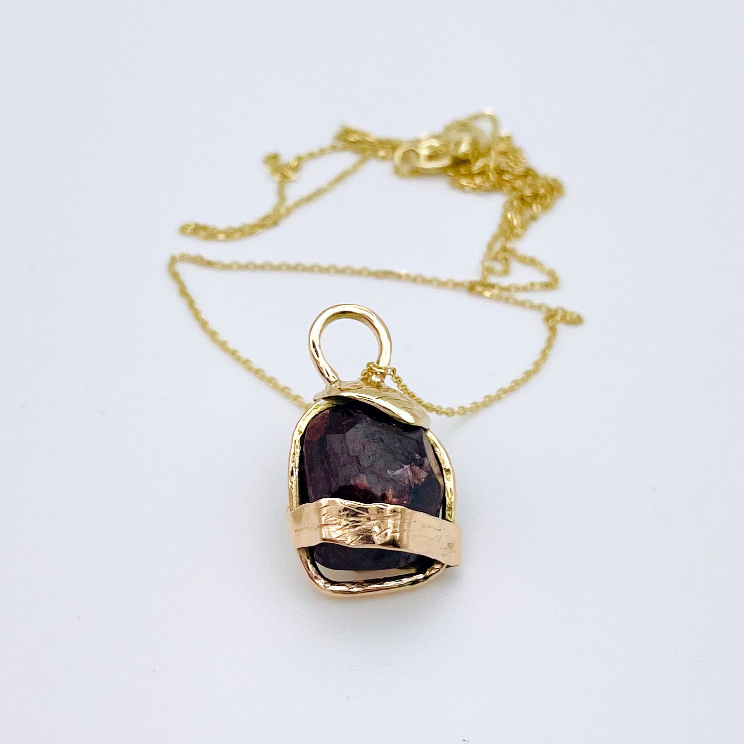 The Expanded Skies Raw Garnet Engraved Pendant has a beautiful raw Norwegian garnet set in 9ct gold. Handcrafted on the edge of Dartmoor and made from high quality recycled gold, Hallmarked by the London Assay Office. The garnet is housed in gold gateway, understated and beautiful, it can be worn every day or for special occasions. This is a unique piece, one-of-a-kind.