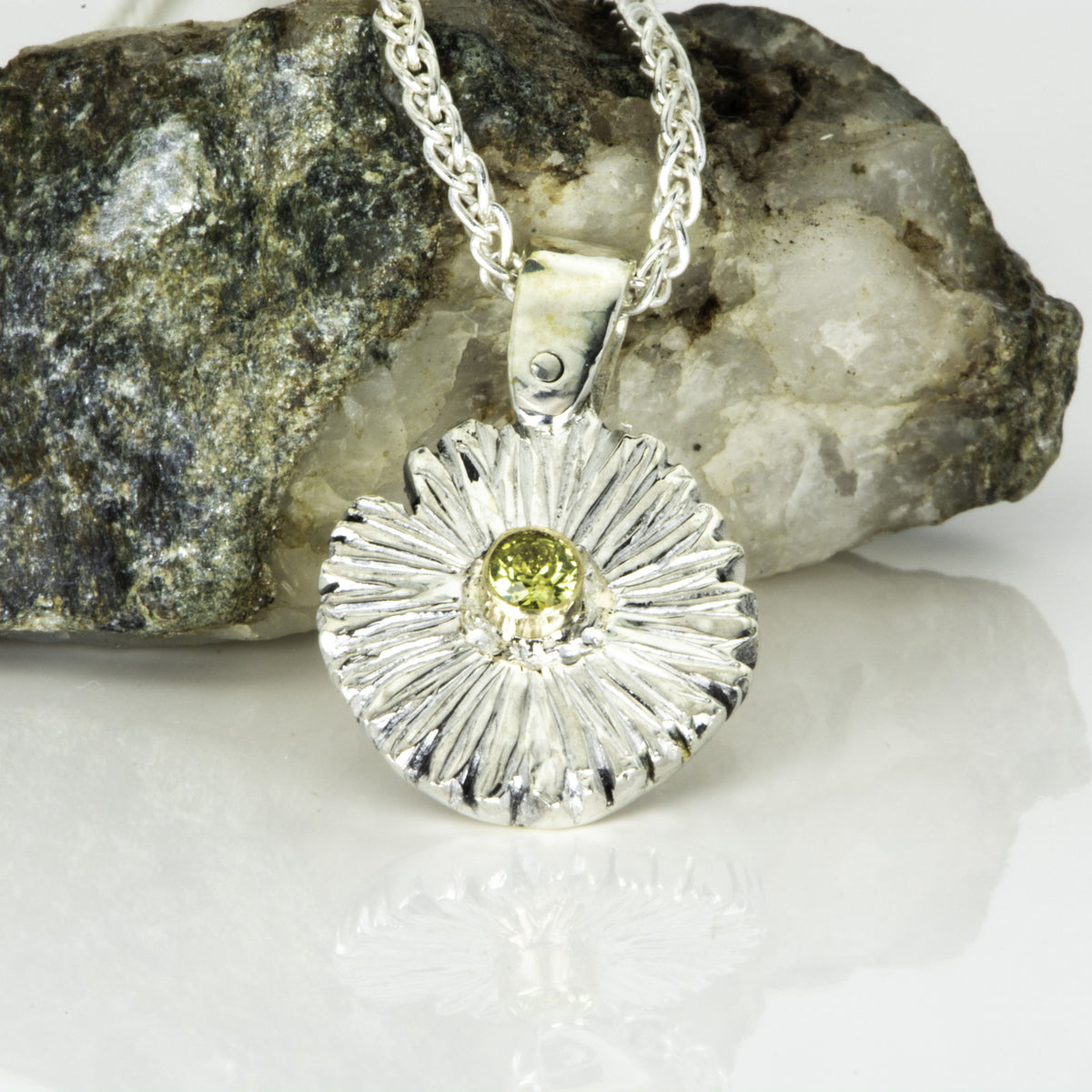The Expanded Skies Dartmoor Daisy Sapphire Necklace in sterling silver and 9ct gold is inspired by the Erigeron Karvinskianus, commonly known as the 'Dartmoor Daisy'. It comes with 16” Italian spiga rolled chain, made from recycled sterling silver. The daisy pendant measures 12mm, the bail measures 6mm, total length 18mm with a depth of 2mm (approx). Each piece is individually saw pierced, hand engraved and
unique. The ethically sourced 2.5mm yellow sapphire is from Queensland, Australia.