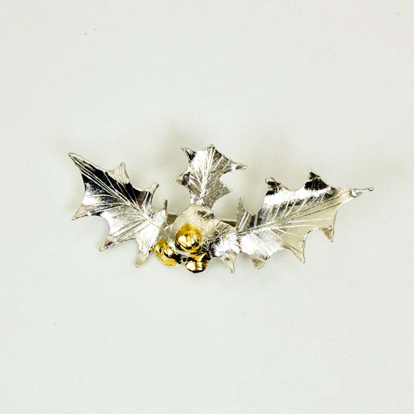 The Expanded Skies Dartmoor Holly Brooch celebrates the sculptural beauty of this native tree.

Totally handcrafted on the edge of Dartmoor and made from recycled fine and sterling silver fused with 24ct gold accents, applied using the Korean gilding process of keum boo.

Each brooch is unique. A simple and elegant addition to any outfit.