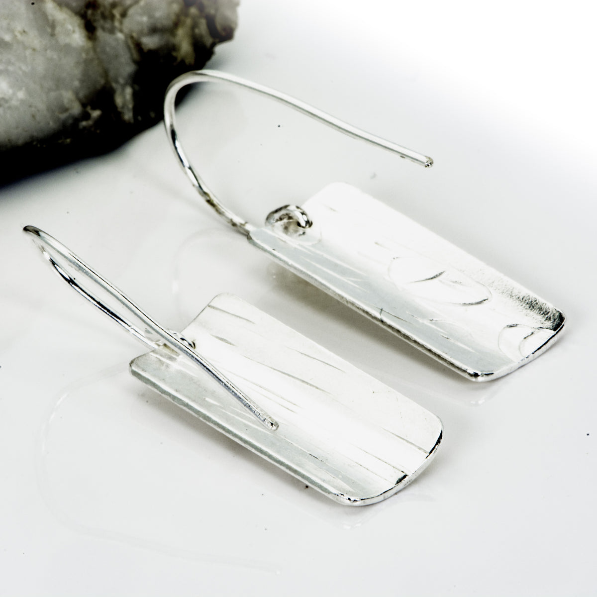 The Expanded Skies Dartmoor Honeysuckle Leaves Drop Earrings are hand engravings of the graceful honeysuckle (Lonicera periclymenum) as it winds through the trees and brambles in Ausewell Woods.Handcrafted in recycled fine silver with recycled 24ct gold accents with sterling silver ear wires. Each earring’s hand engraving is unique. Simple and elegant with a textured, polished finish, they can be worn everyday for any occasion. The earrings are totally handcrafted on the edge of Dartmoor. Reverse shown