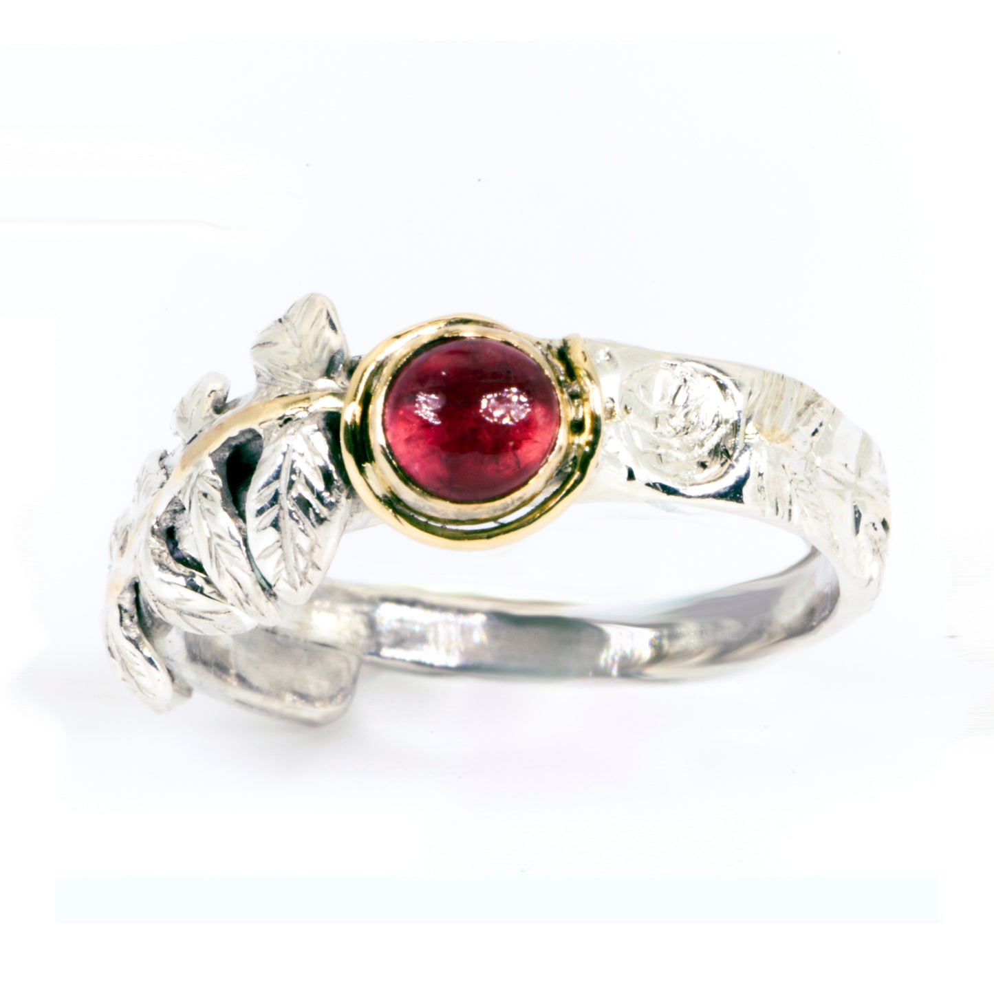 Expanded Skies Dartmoor Rowan Leaf and Berries Spinel Ring. The Expanded Skies Dartmoor Rowan Leaf and Berries Spinel Ring is totally handcrafted on the edge of Dartmoor. The ring is created in recycled sterling silver, inlaid with 9ct gold. The ring is set with an ethically sourced Tanzanian red-pink spinel, set in 9ct gold, with a hand formed rowan leaf, inlaid with 9ct gold. The ethically sourced 4.5mm round spinel is from Moyo Gems. Moyo gems is run by female miners Tanzanian Women Miners' Association.