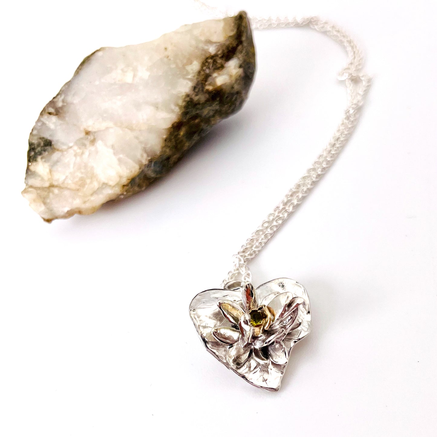 Expanded Skies Expanded Skies Celandine Sapphire Pendant, inspired by the profusion of celandine petals found in the meadow near Cuddyford and all along the Dartmoor byways, pure joy! With a 9ct gold or sterling silver chain. Pendant with 16 inch sterling silver chain pictured.