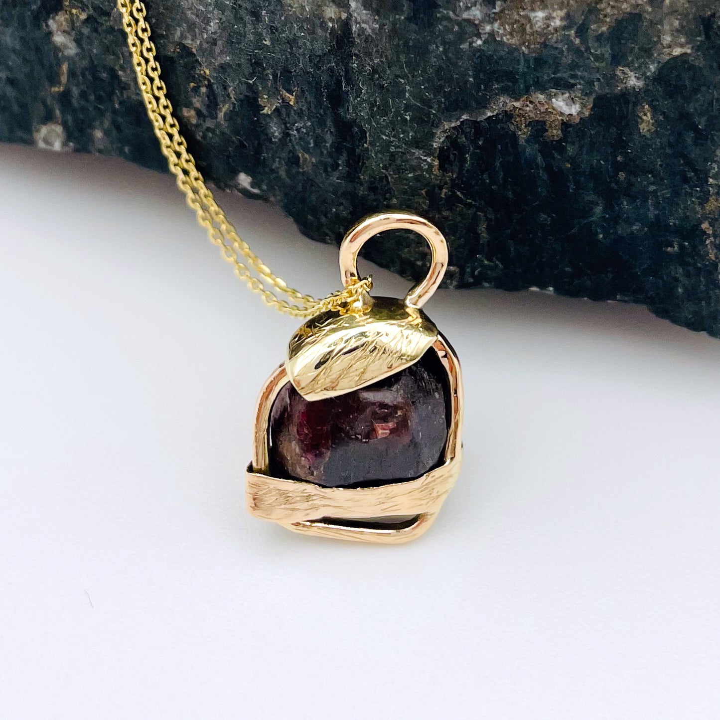 The Expanded Skies Raw Garnet Engraved Pendant has a beautiful raw Norwegian garnet set in 9ct gold. Handcrafted on the edge of Dartmoor and made from high quality recycled gold, Hallmarked by the London Assay Office. The garnet is housed in gold gateway, understated and beautiful, it can be worn every day or for special occasions. This is a unique piece, one-of-a-kind.